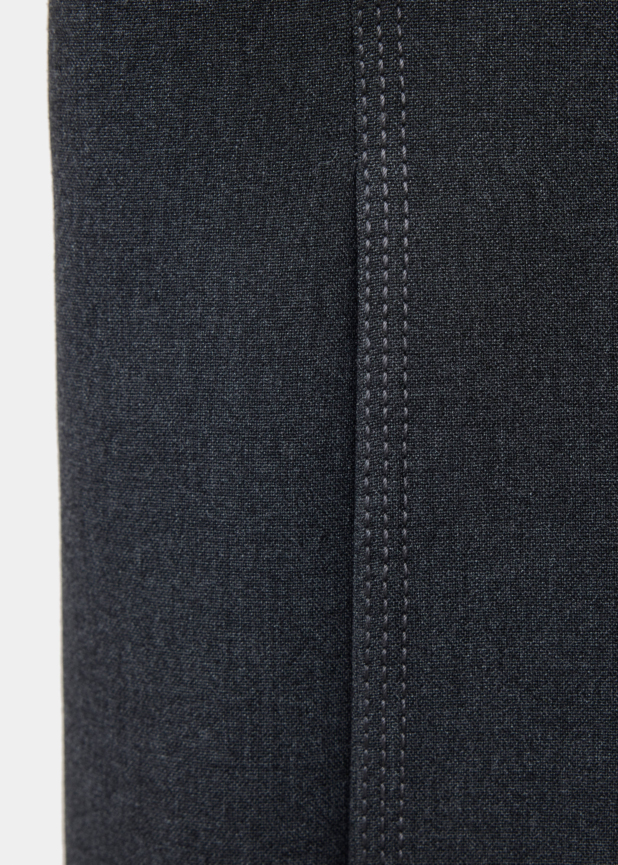 Close-up of dark grey blazer fabric and topstitching detail.