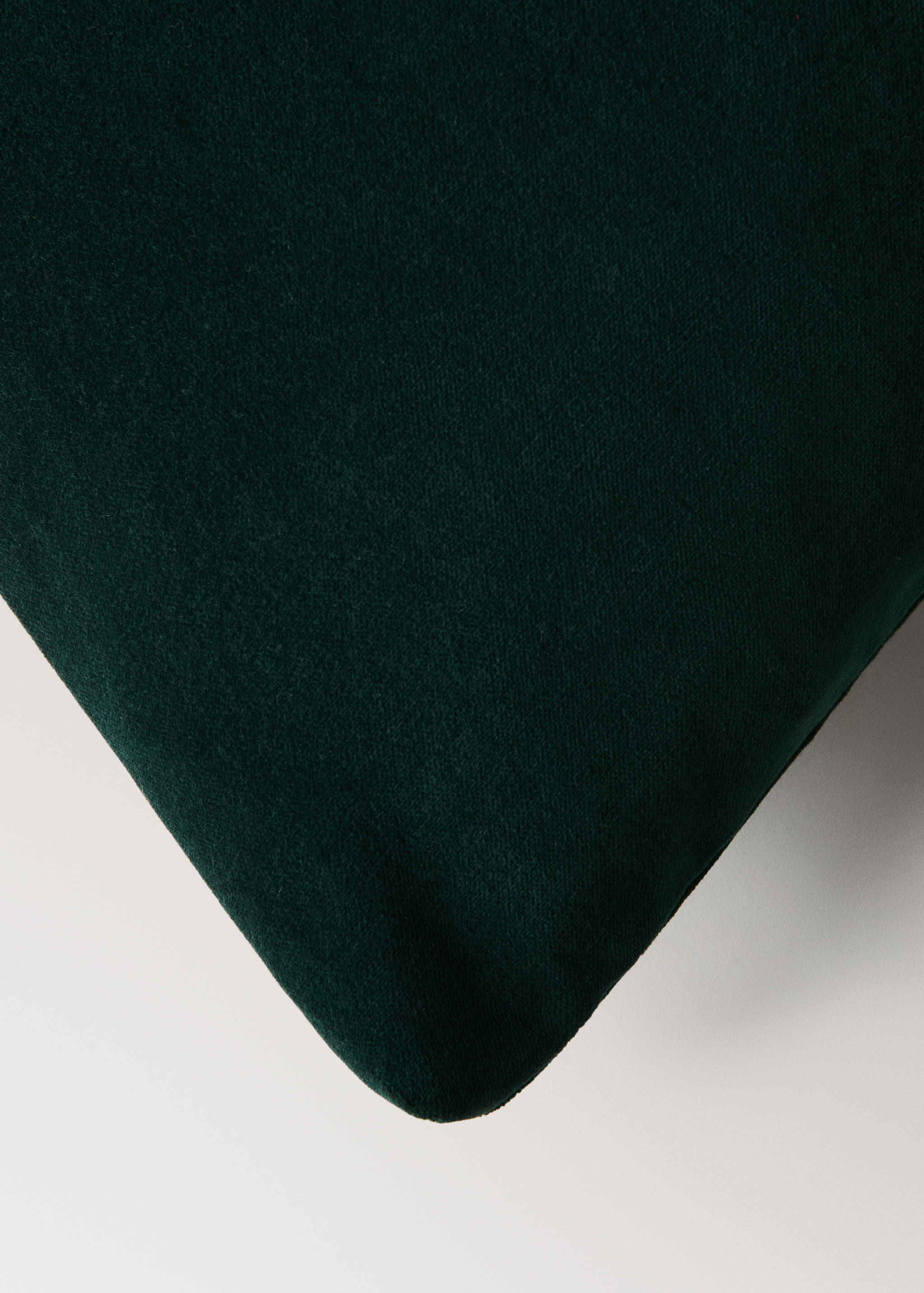 Dark green velvet cushion cover close-up.