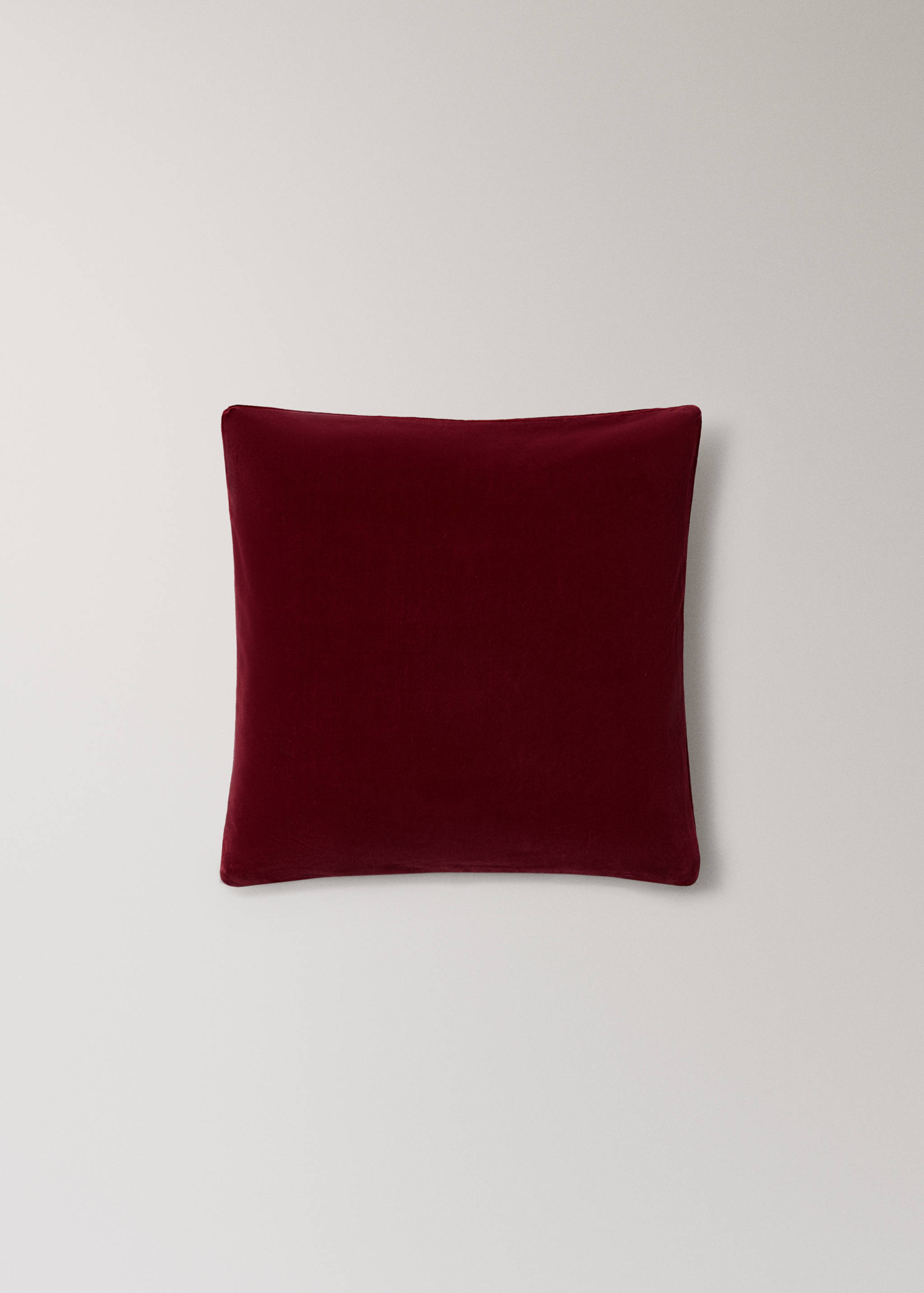 Dark red cushion cover with a soft texture.