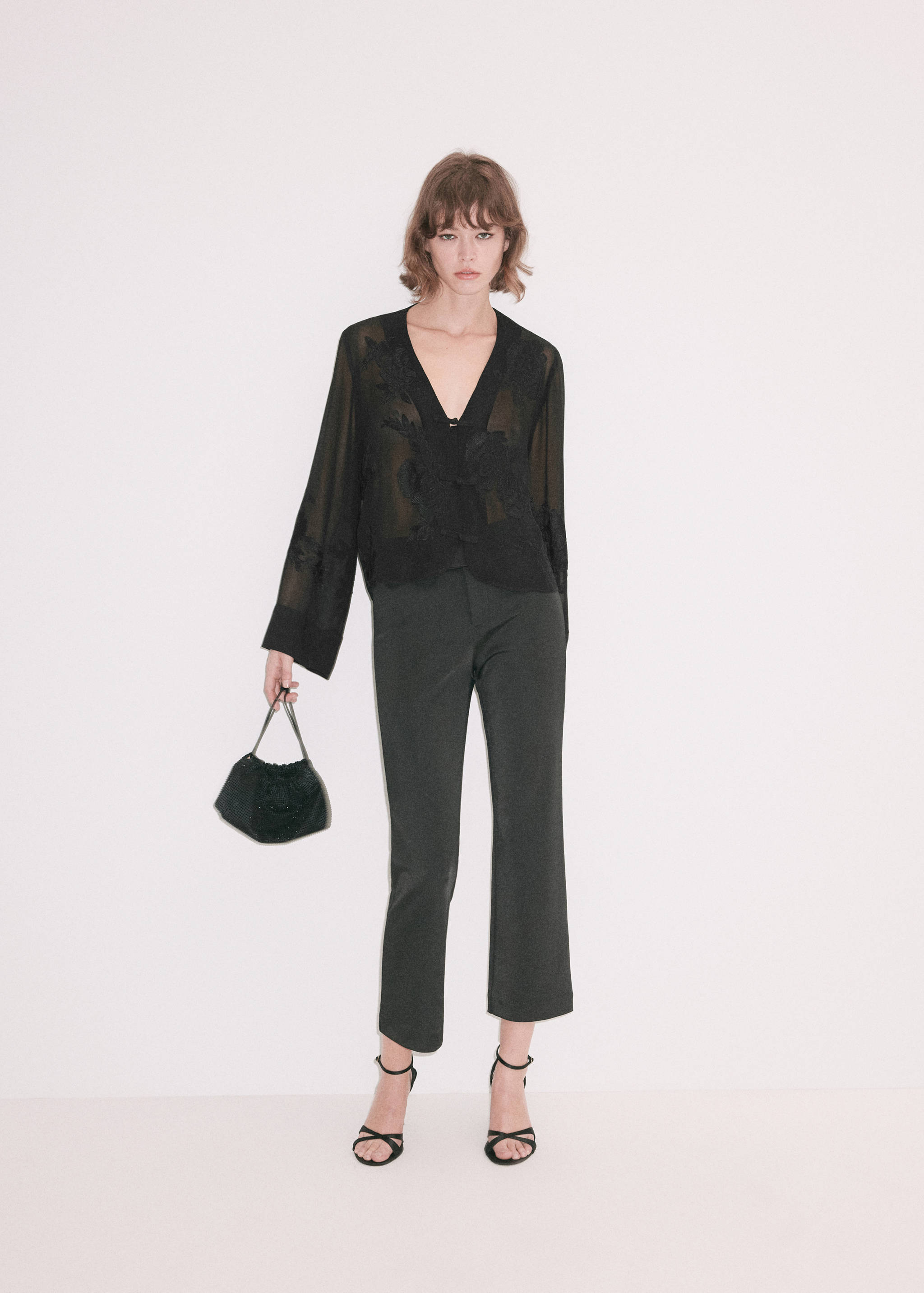 Blusa negra transparente con bordados, manga larga y pantalones.