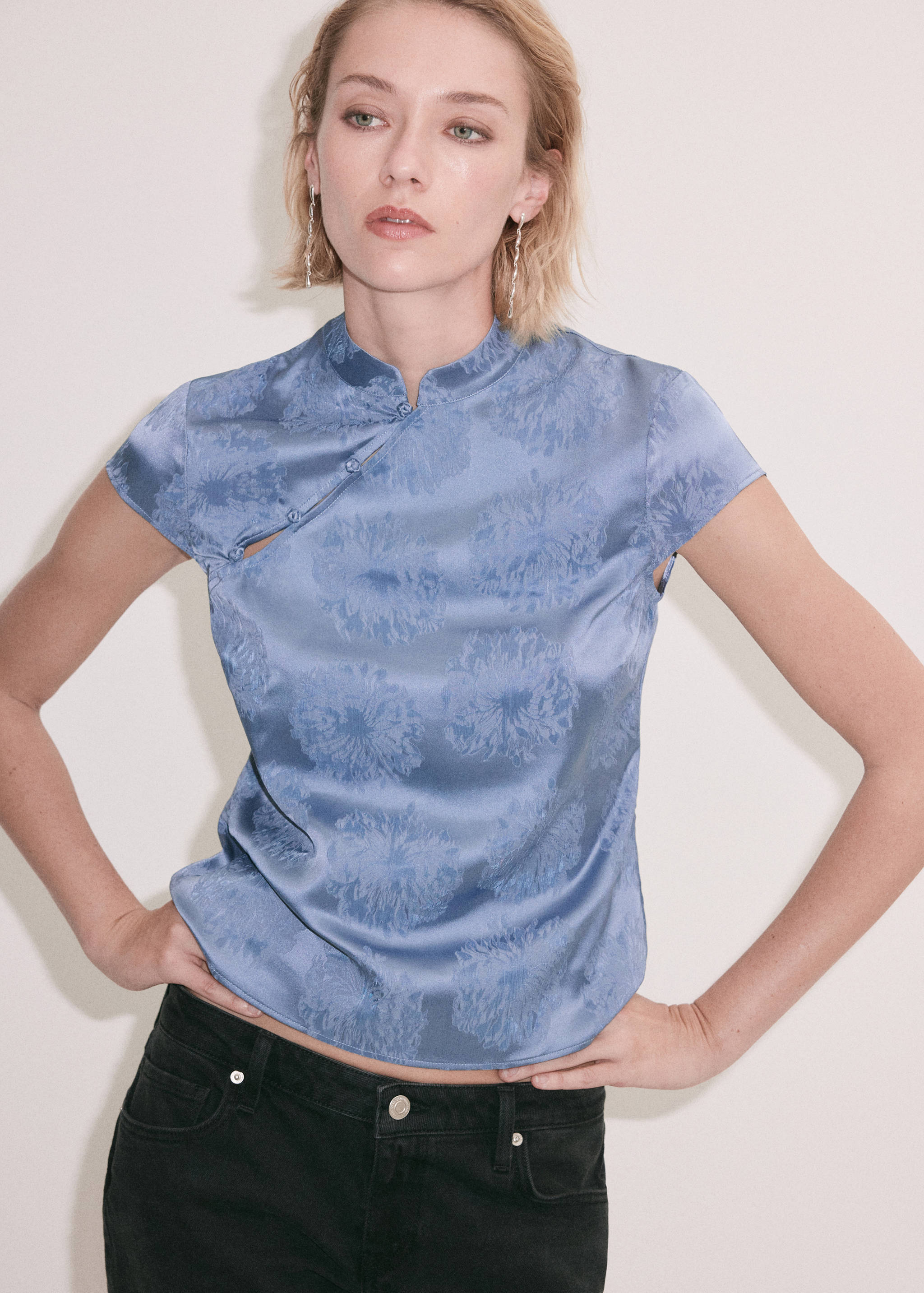 Blusa de satén con jacquard floral en azul, cuello mao y manga corta capa.