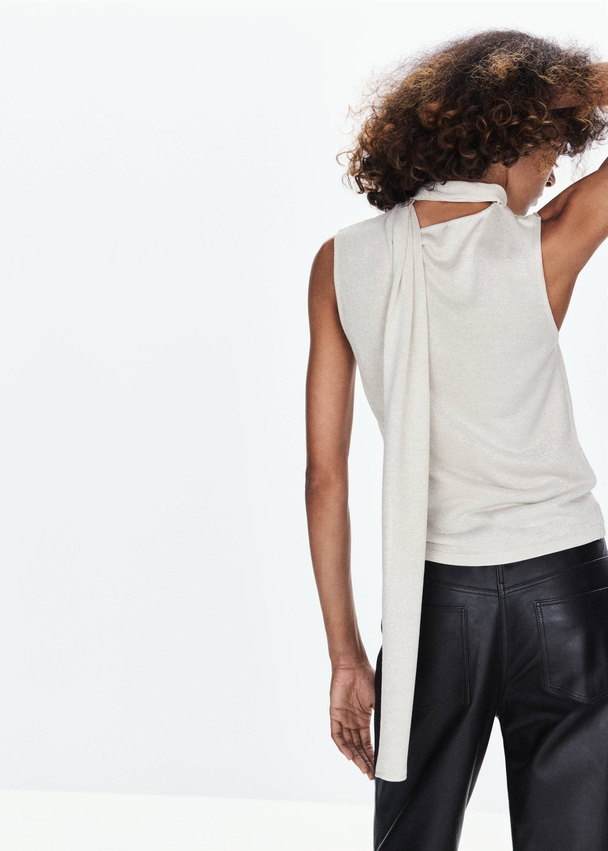 Beige metallic sleeveless top with a high neck and long back drape, back view.