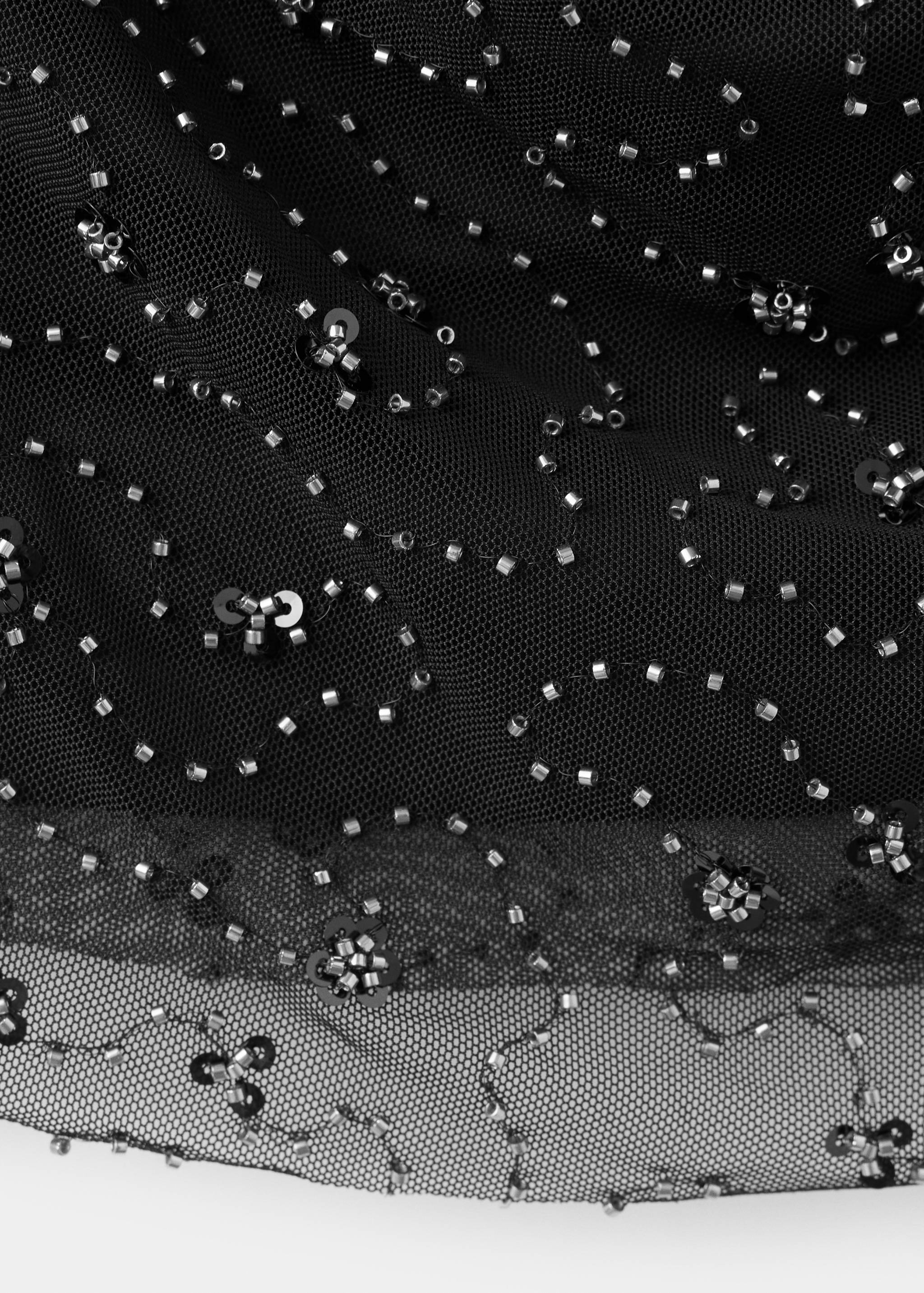 Close-up of a black beaded mesh top fabric.