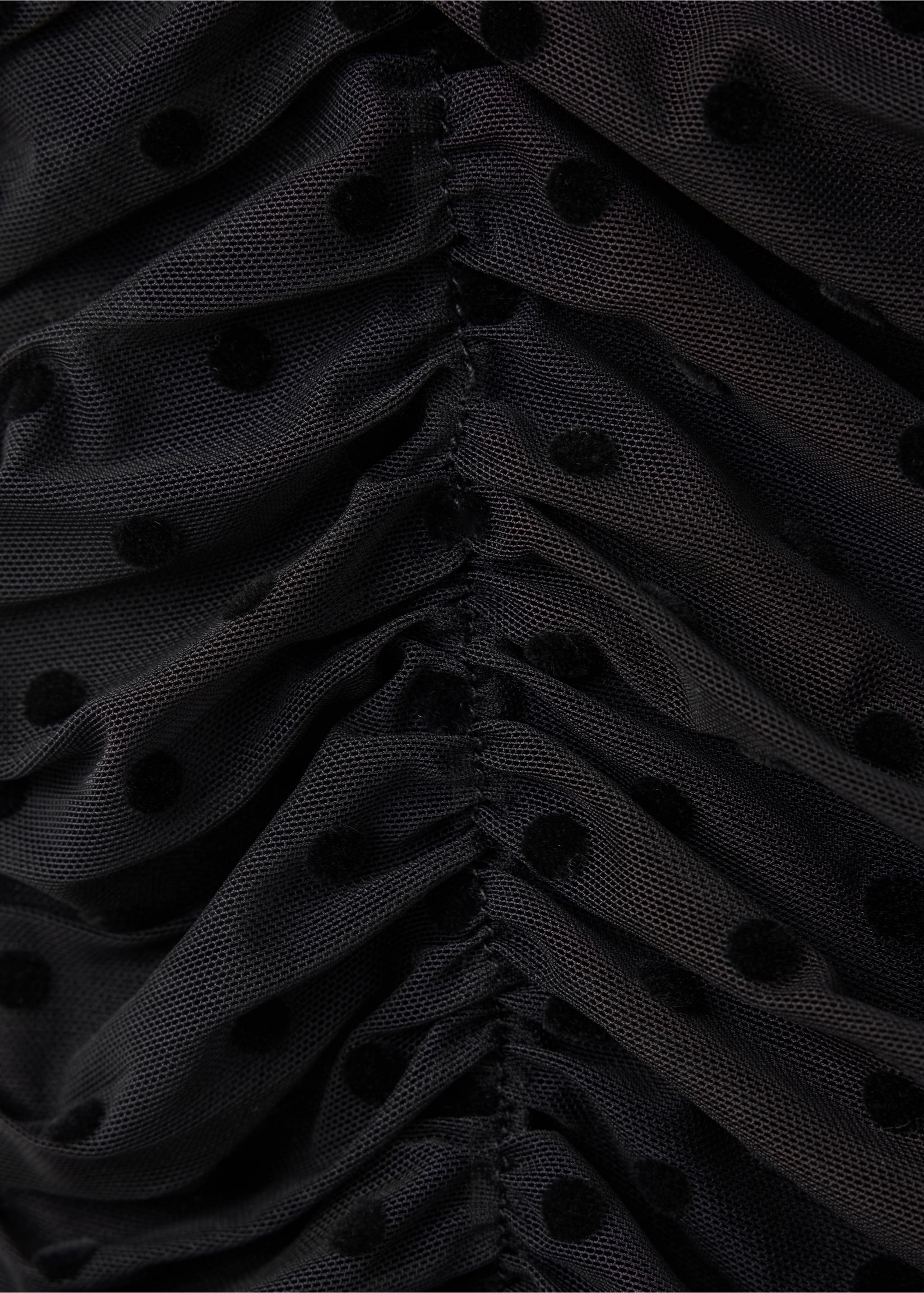 Close-up of a black mesh top with flocked dots and ruching., Black. Ref: 37019131-00.