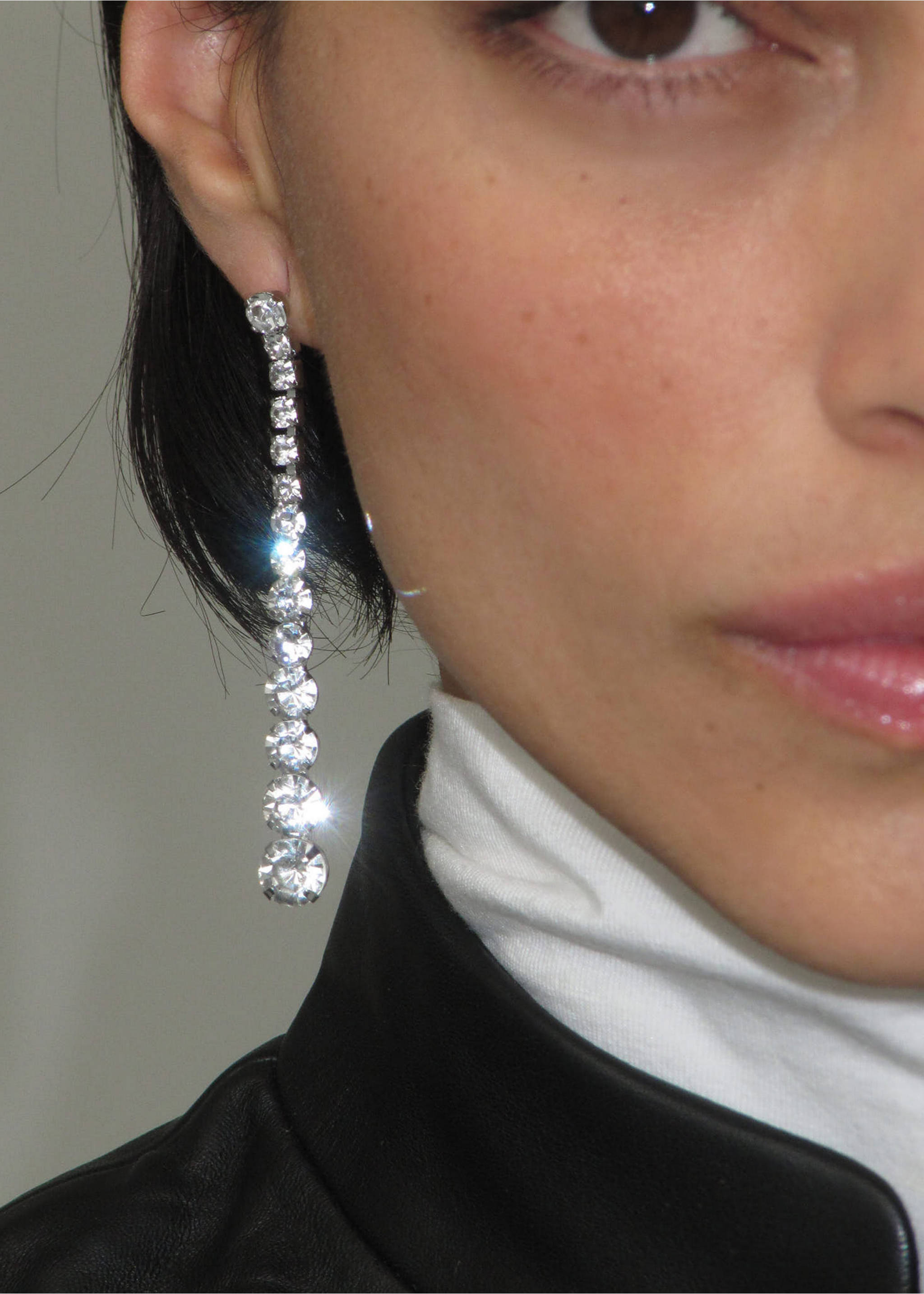Long silver-tone rhinestone drop earring worn on the model's ear., Silver. Ref: 37019139-00.