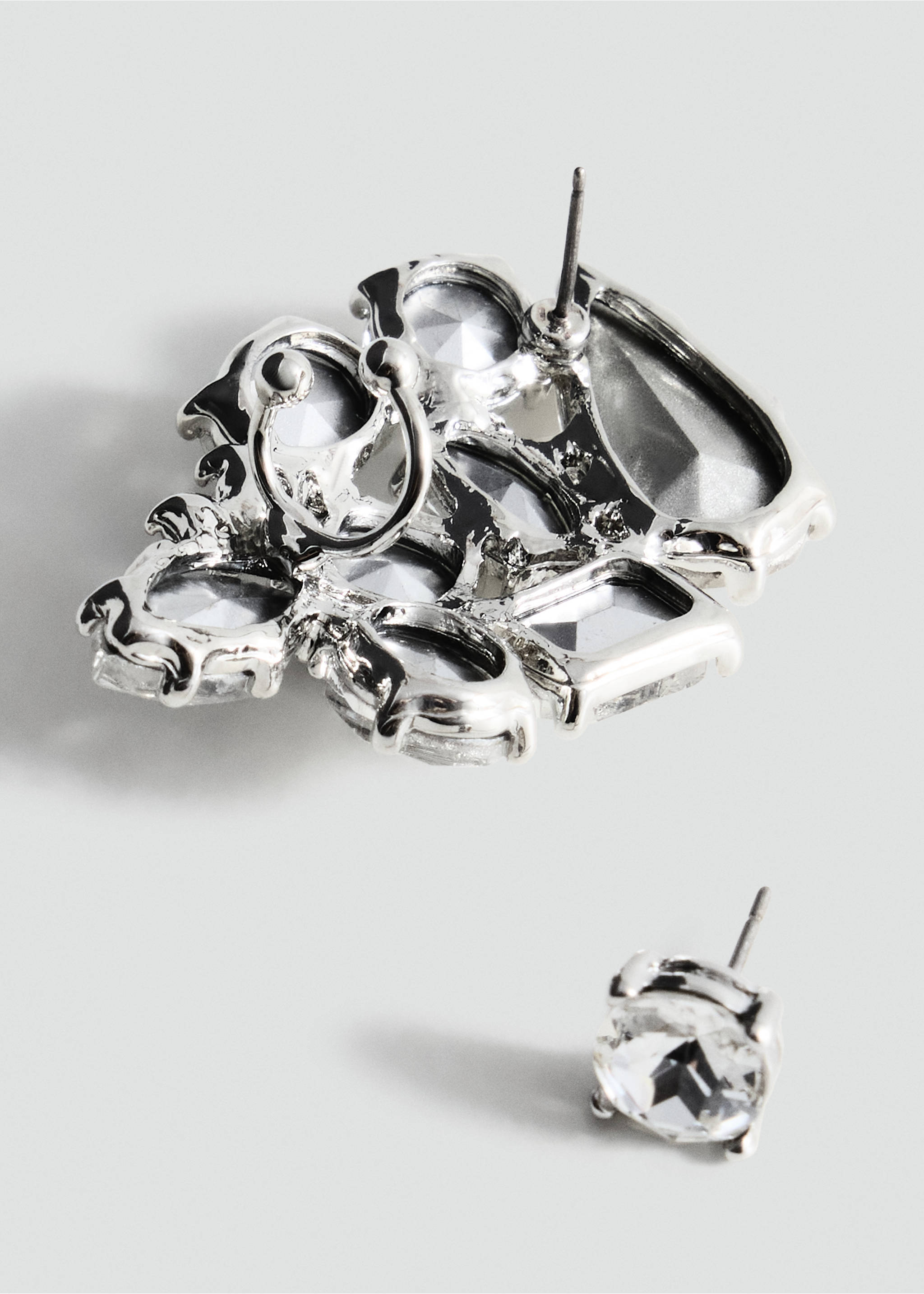 Close-up of silver-tone stud earrings with faceted clear stones., Silver. Ref: 37019140-00.