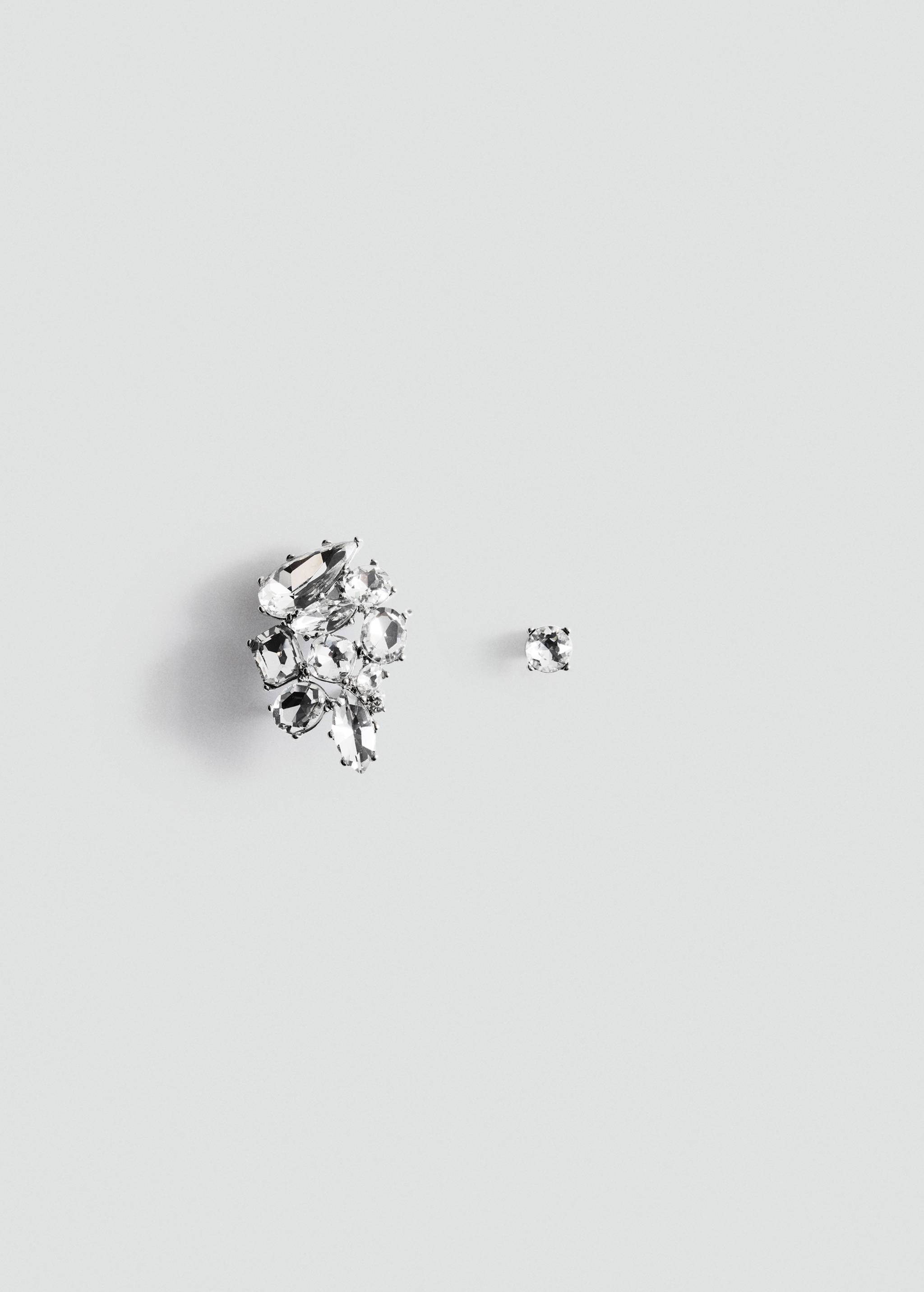 Asymmetrical silver-tone earrings with faceted clear crystals in a clustered design.