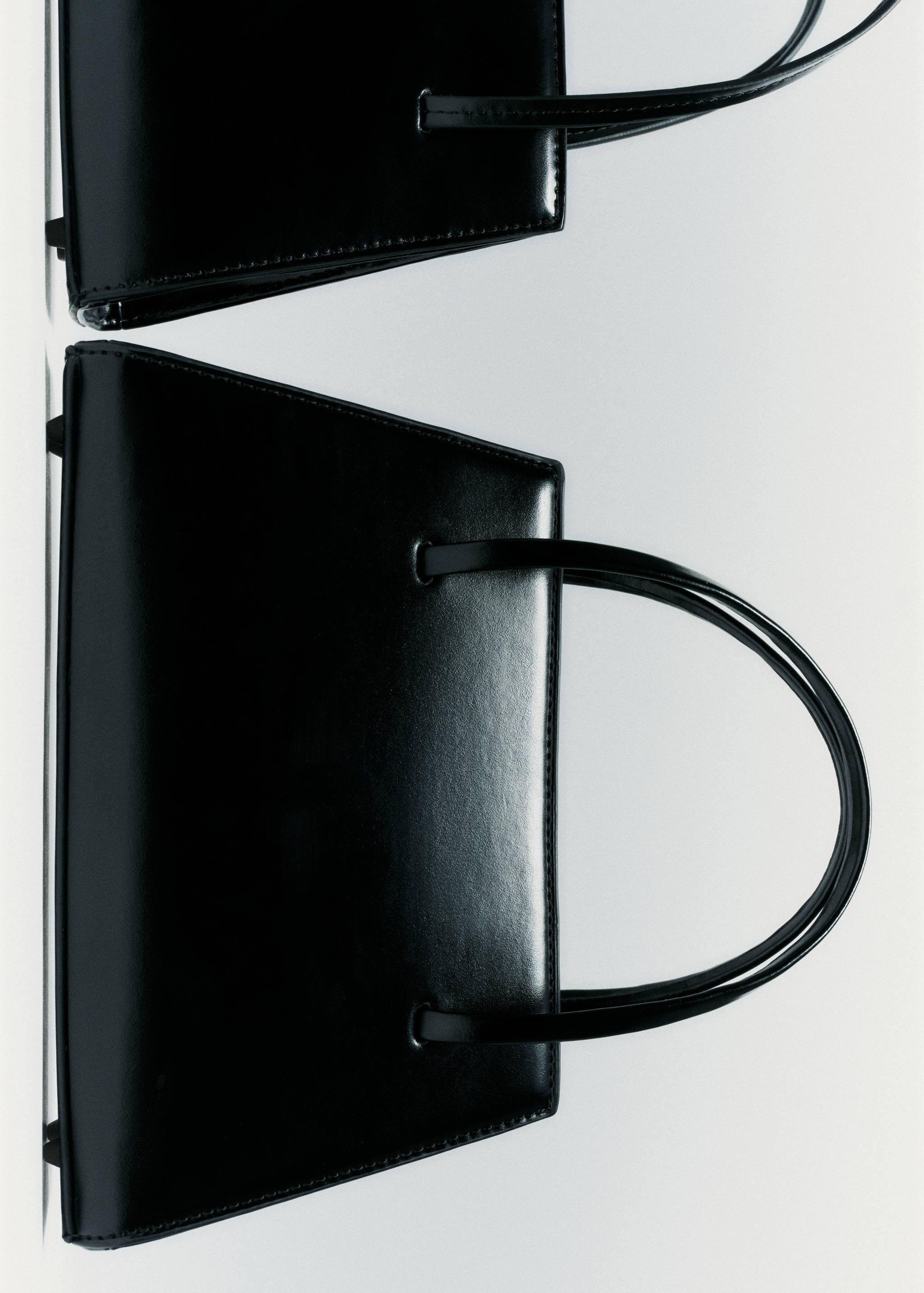 Structured black handbag with twin shoulder straps.
