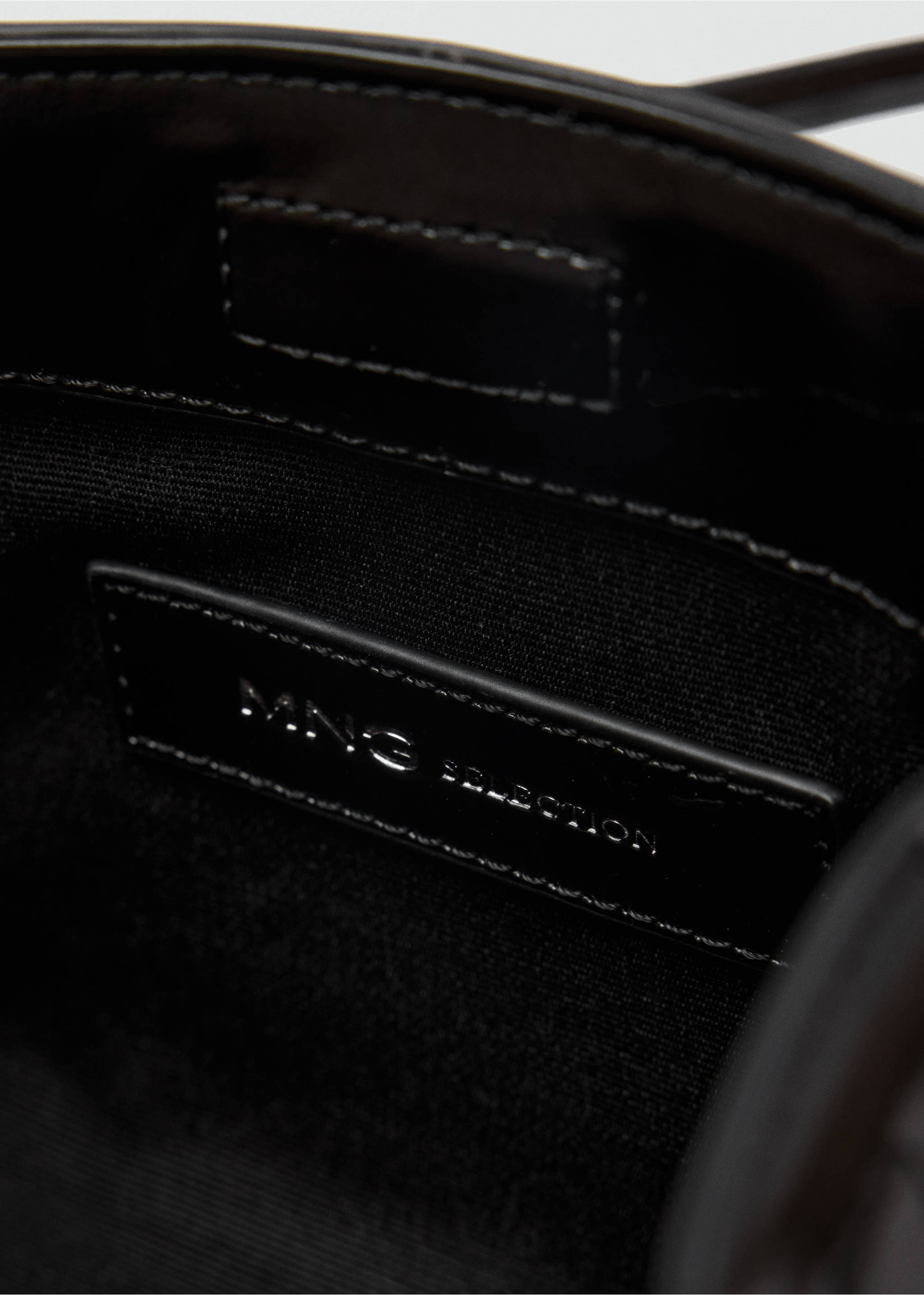 Close-up of a handbag interior showing the MNG SELECTION inner label., Black. Ref: 37019143-00.