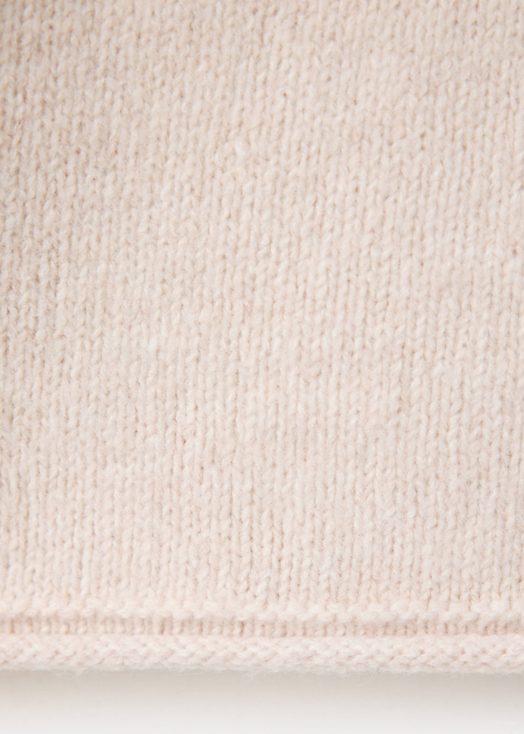 Close-up of a beige jersey knit fabric texture.