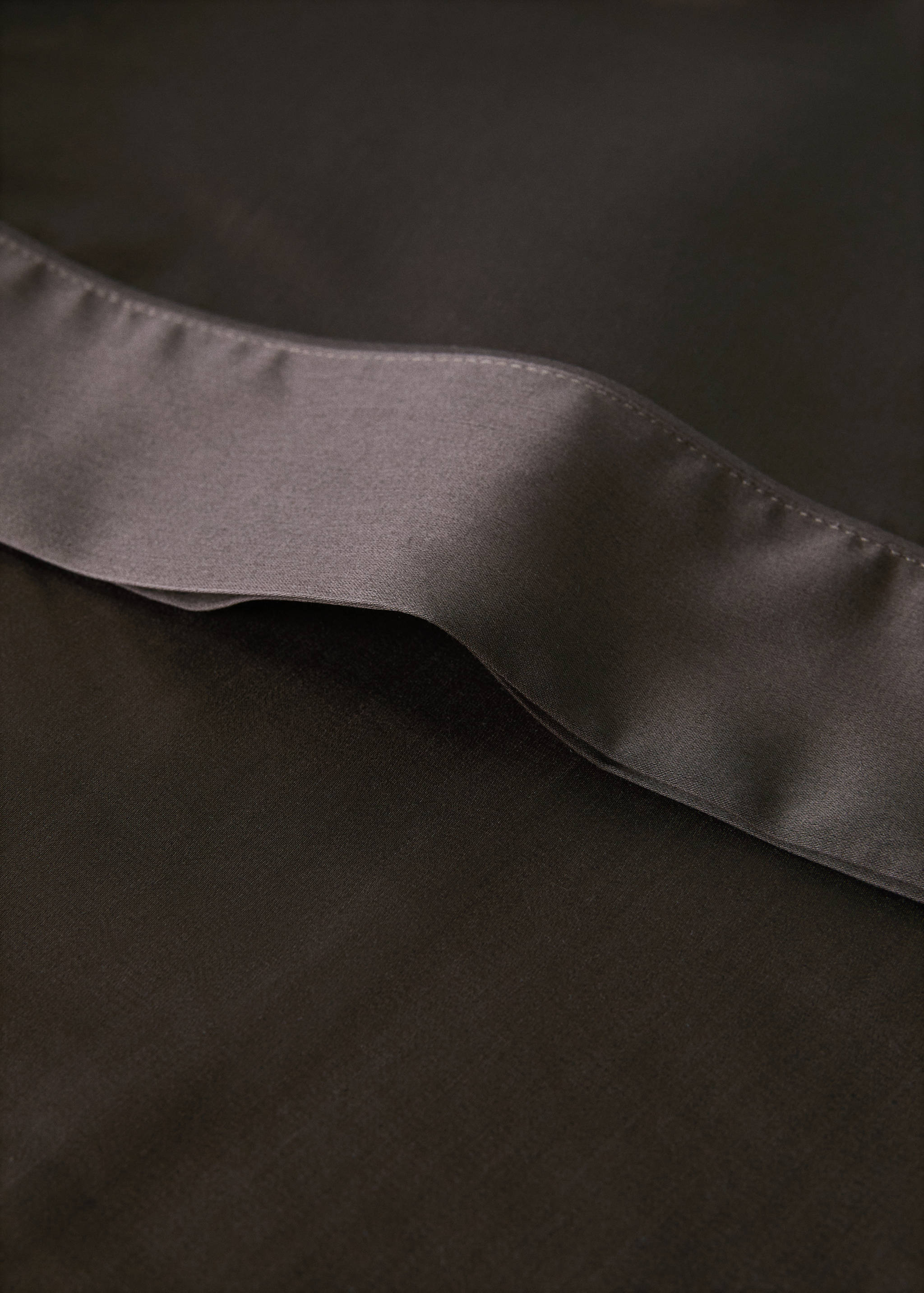 Dark brown pillowcase detail showing a contrasting smooth border.
