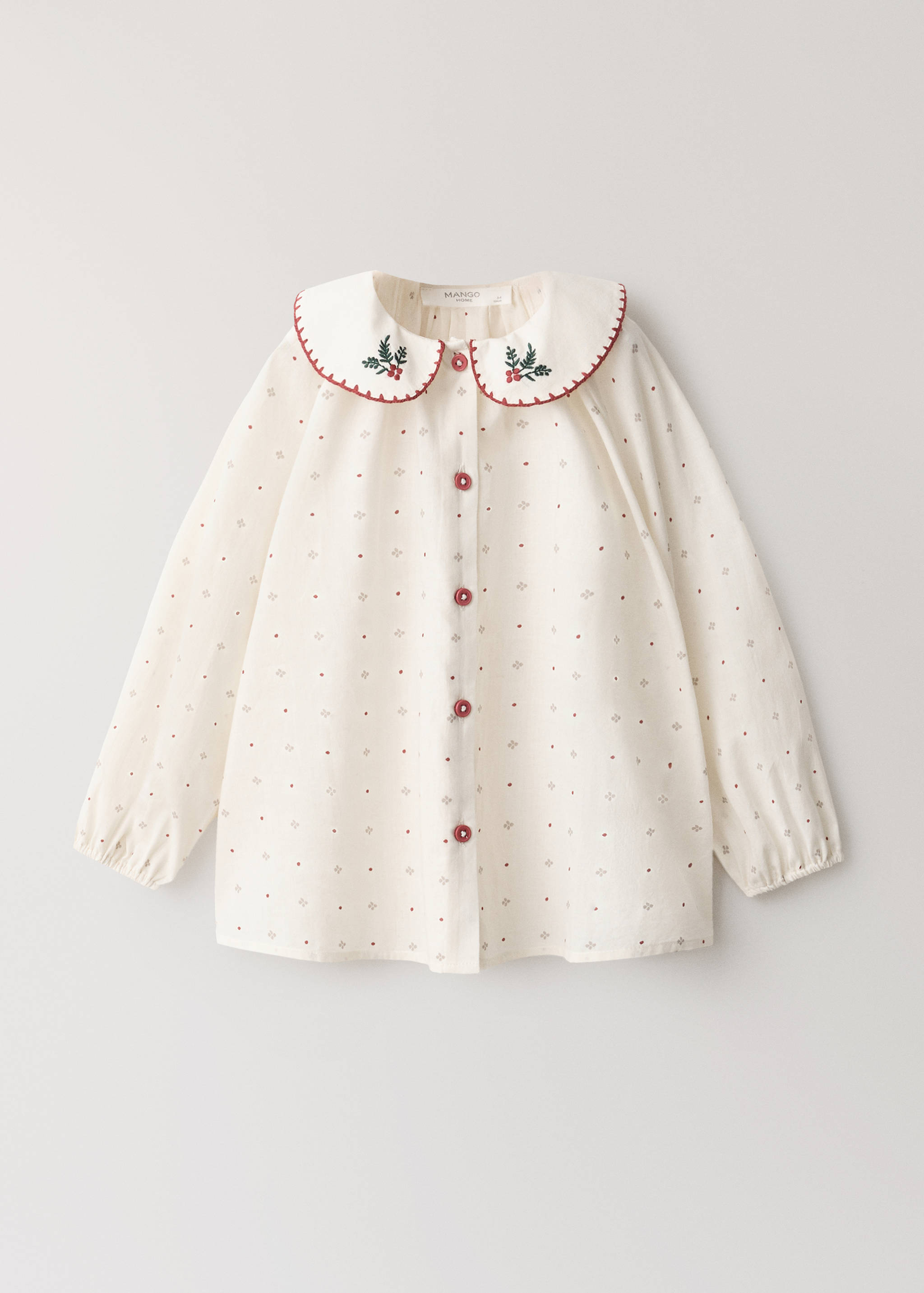 Off-white patterned pyjama shirt featuring a Peter Pan collar with embroidery and reddish-brown buttons.