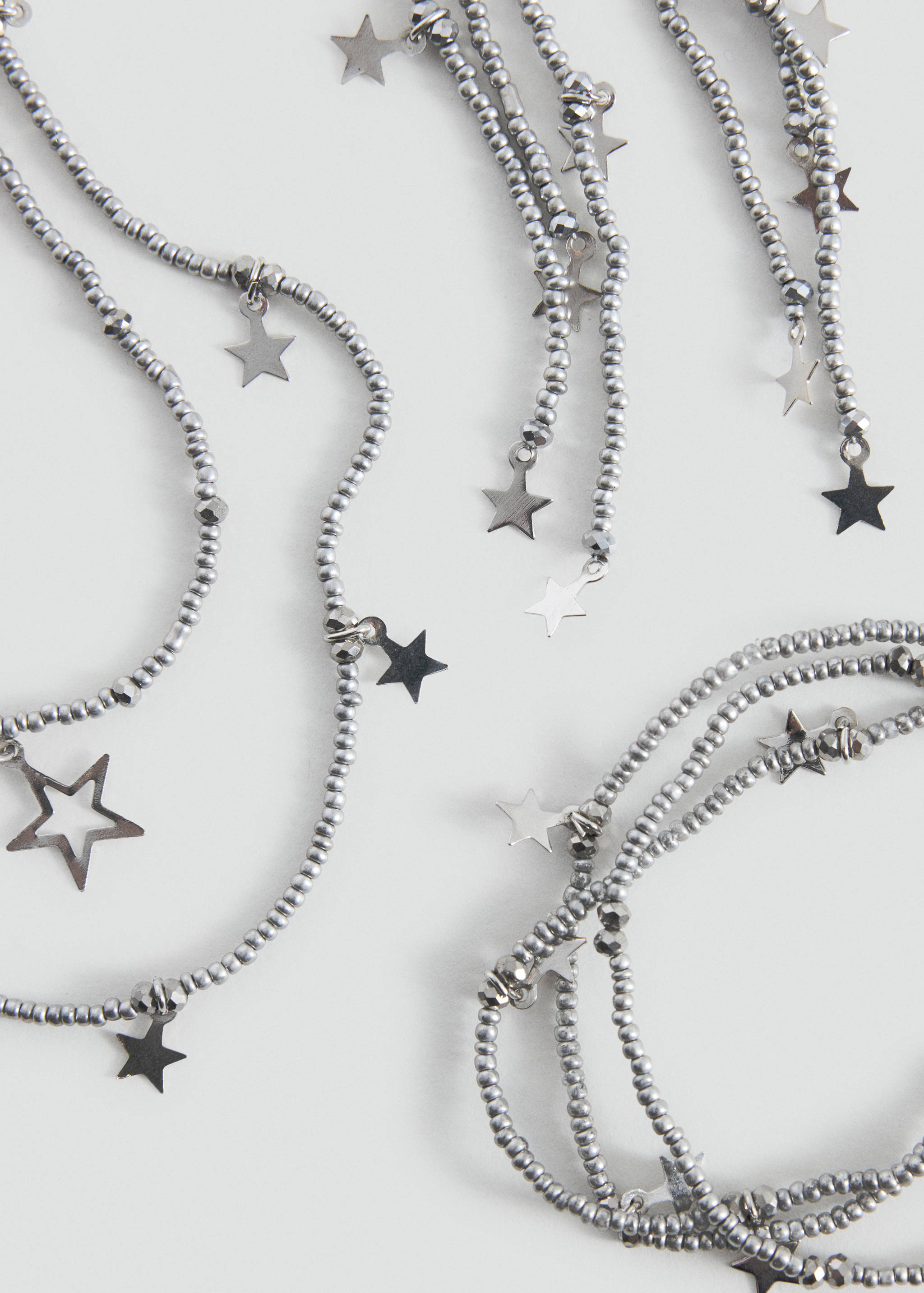 Silver beaded collar necklace with hanging star charms.