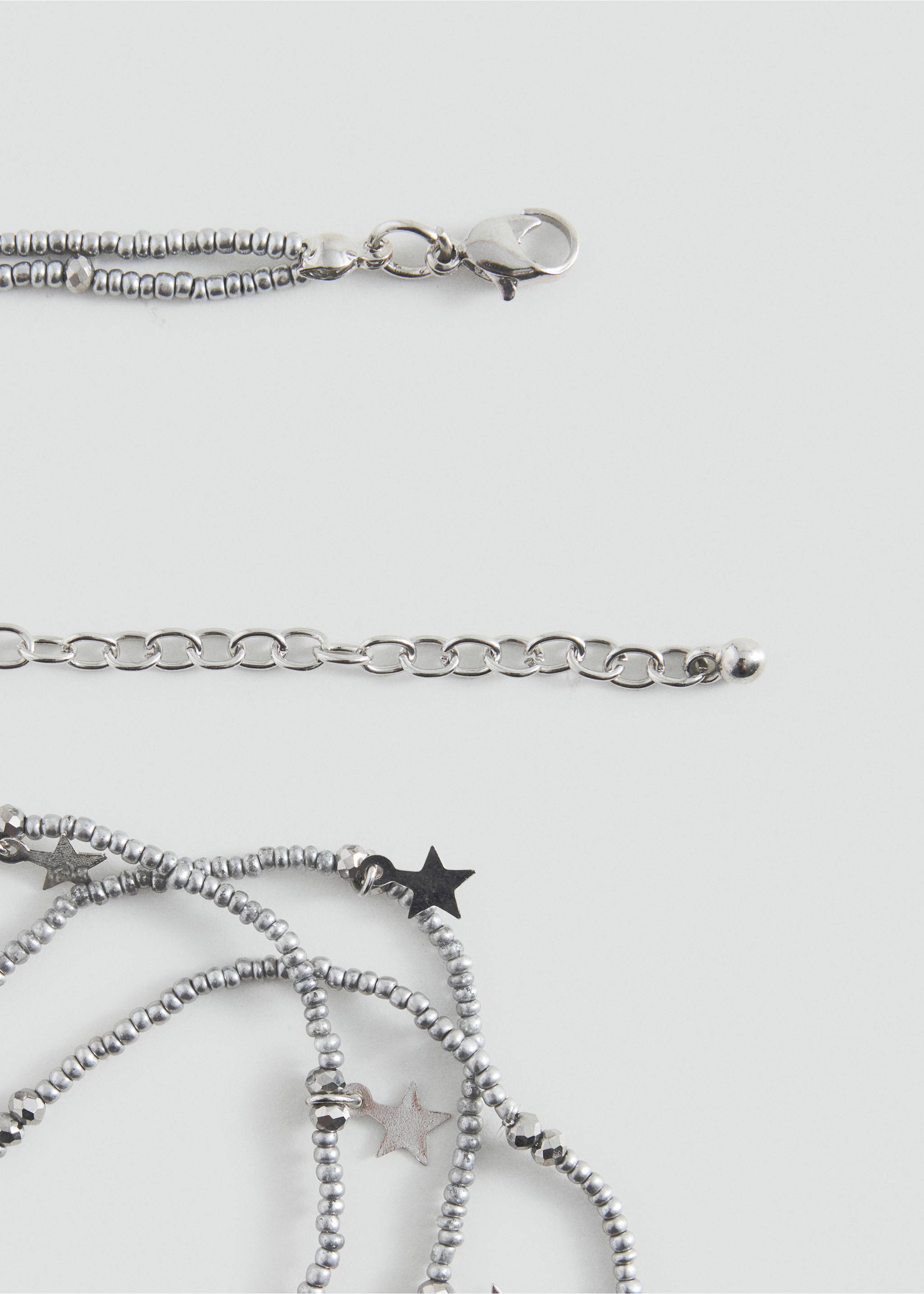 Close-up of a silver-toned beaded necklace with star charms and adjustable clasp., Silver. Ref: 37025195-00.
