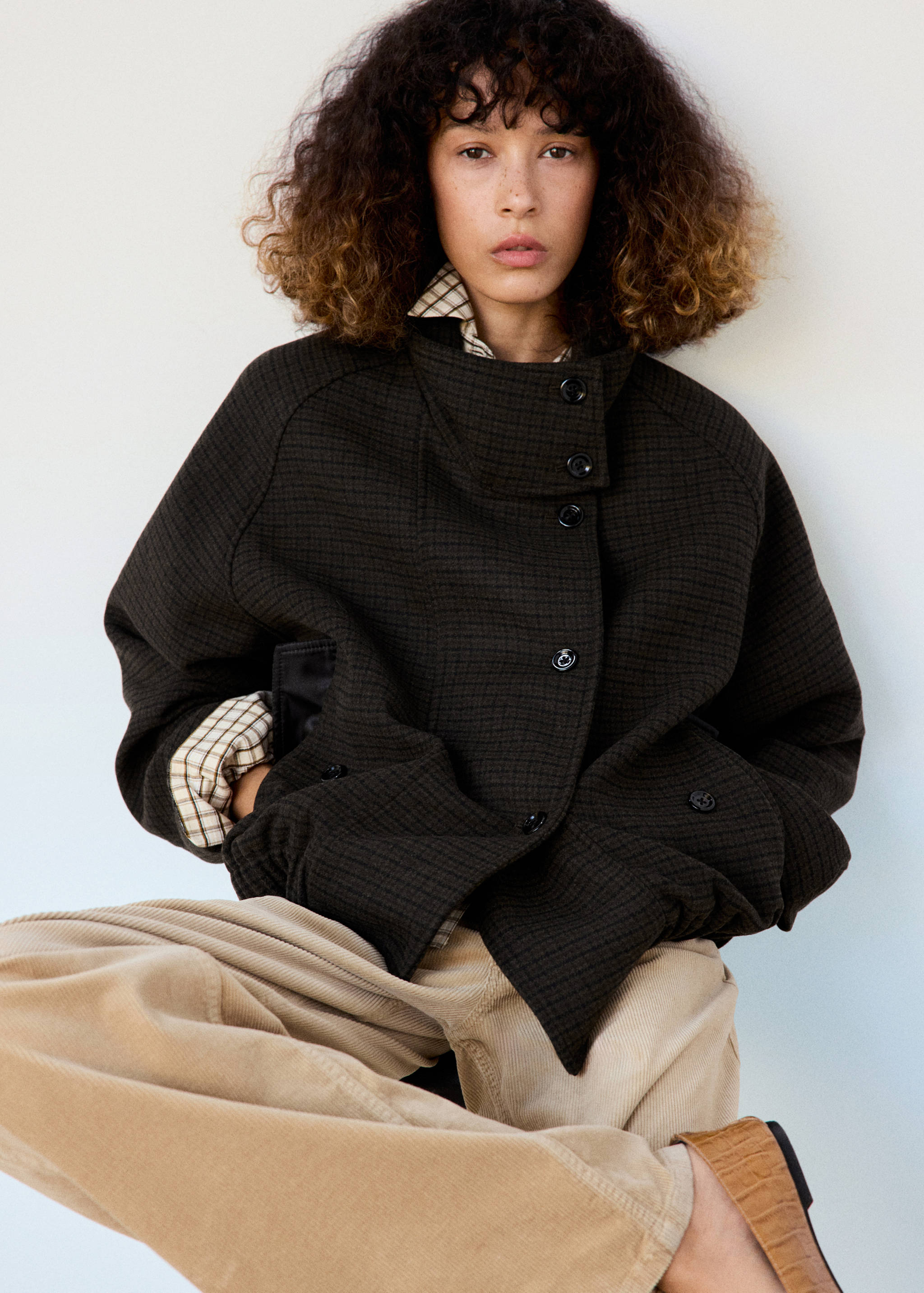 Dark brown patterned jacket with high collar and front buttons.