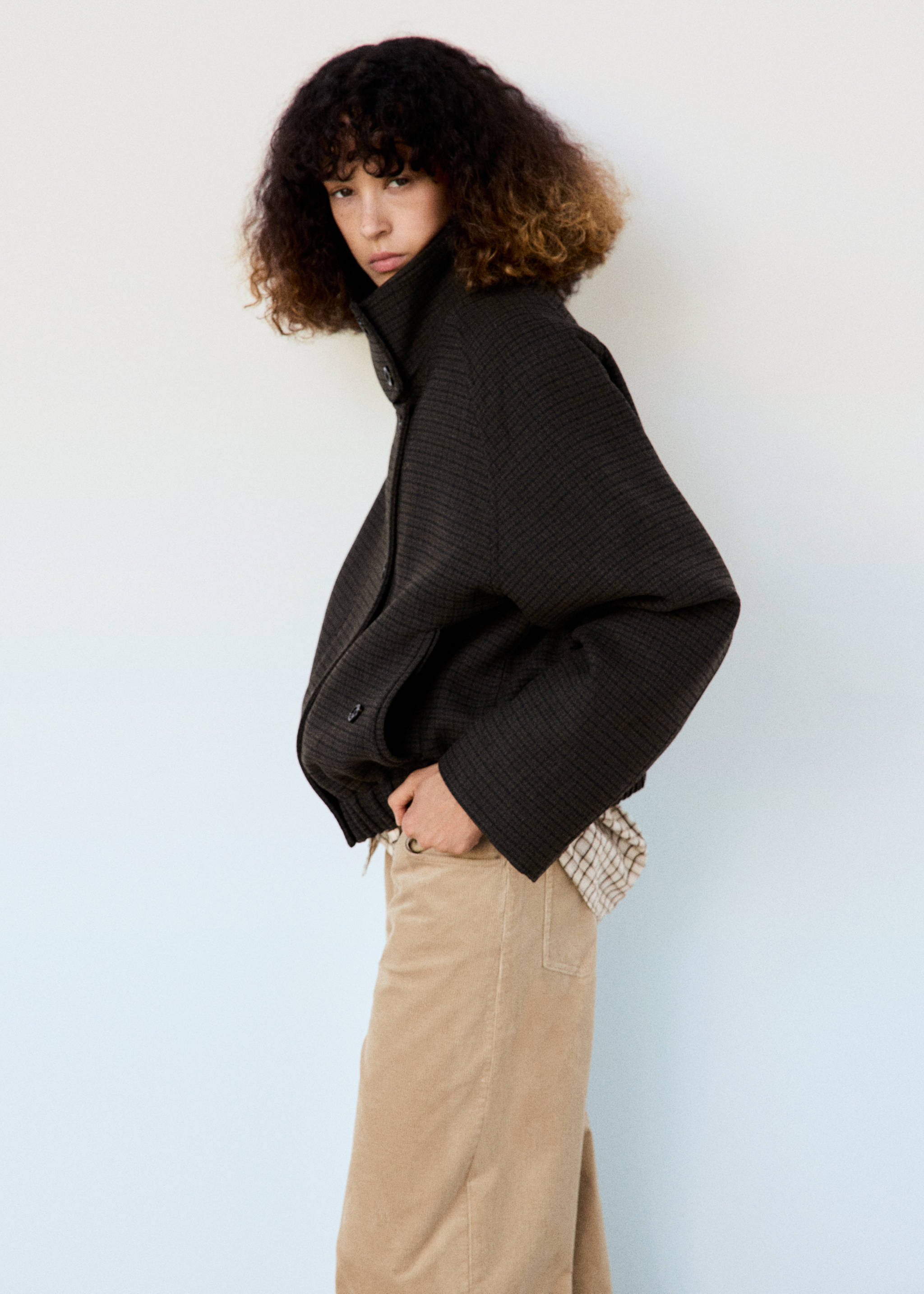 Dark brown textured knit jacket with a high funnel collar and wide sleeves.