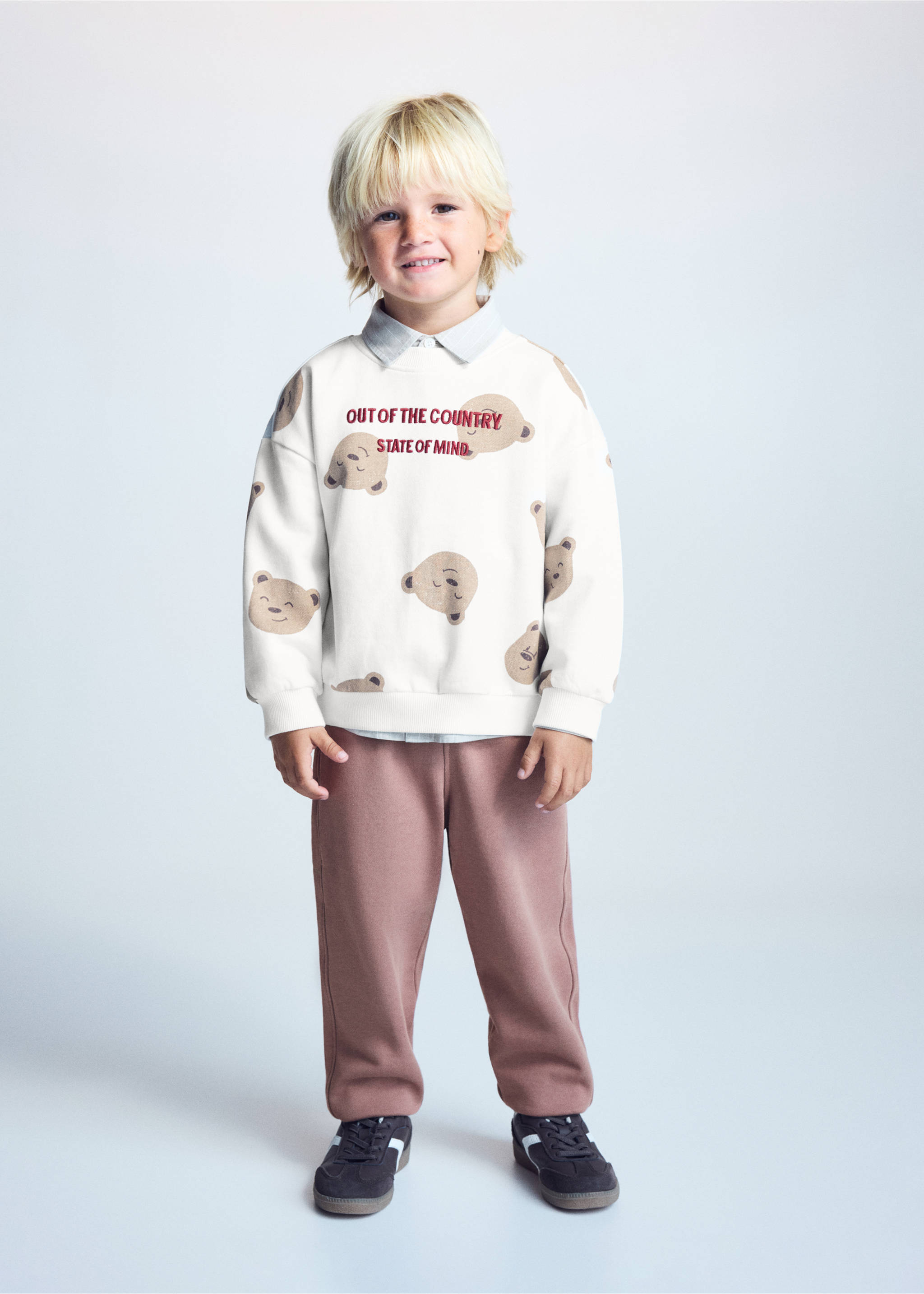 Off-white bear print sweatshirt with red slogan text, layered with a shirt and brown trousers., Off White. Ref: 37026332-00.