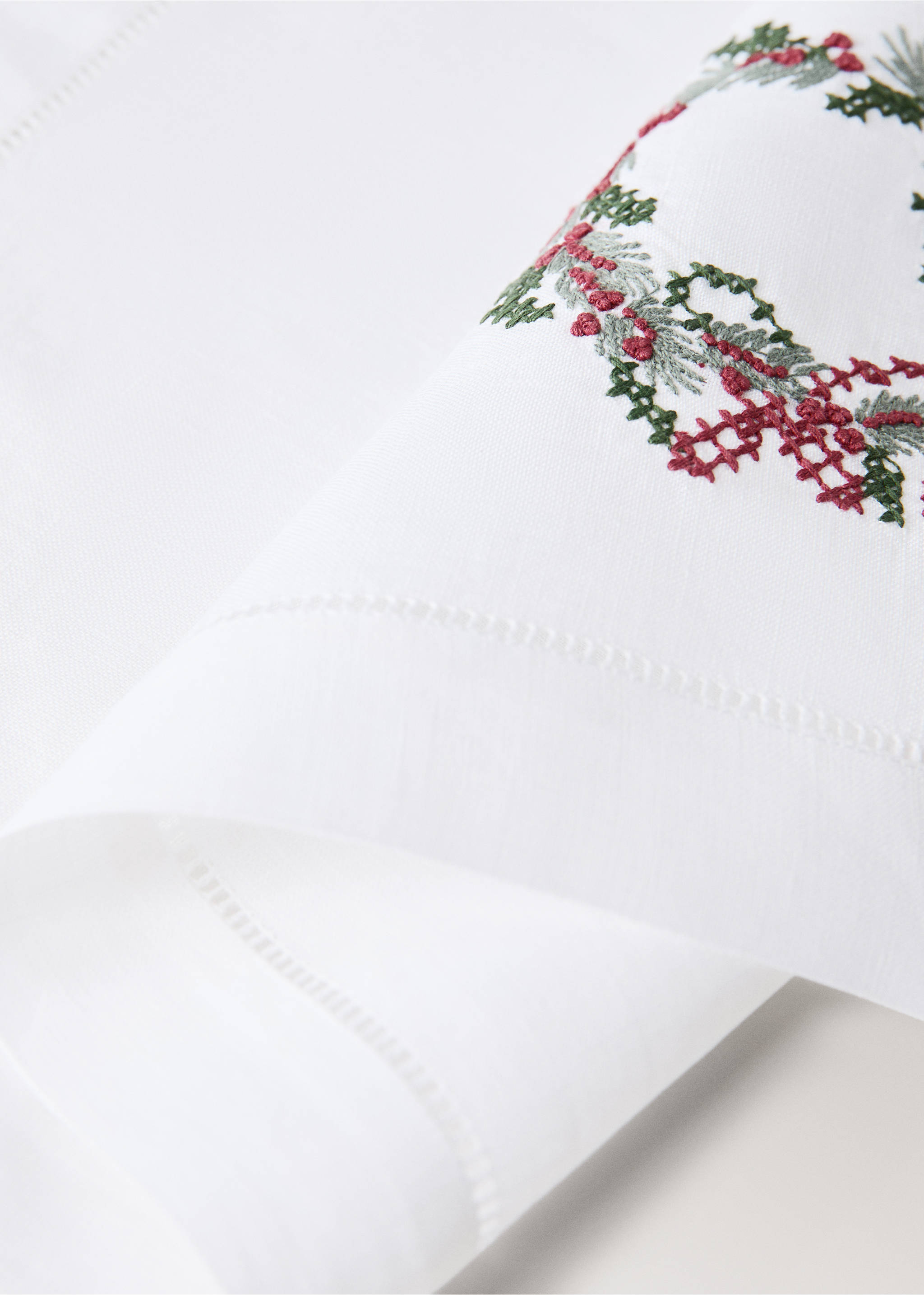 White placemat detail with an embroidered Christmas wreath., White. Ref: 37026334-00.