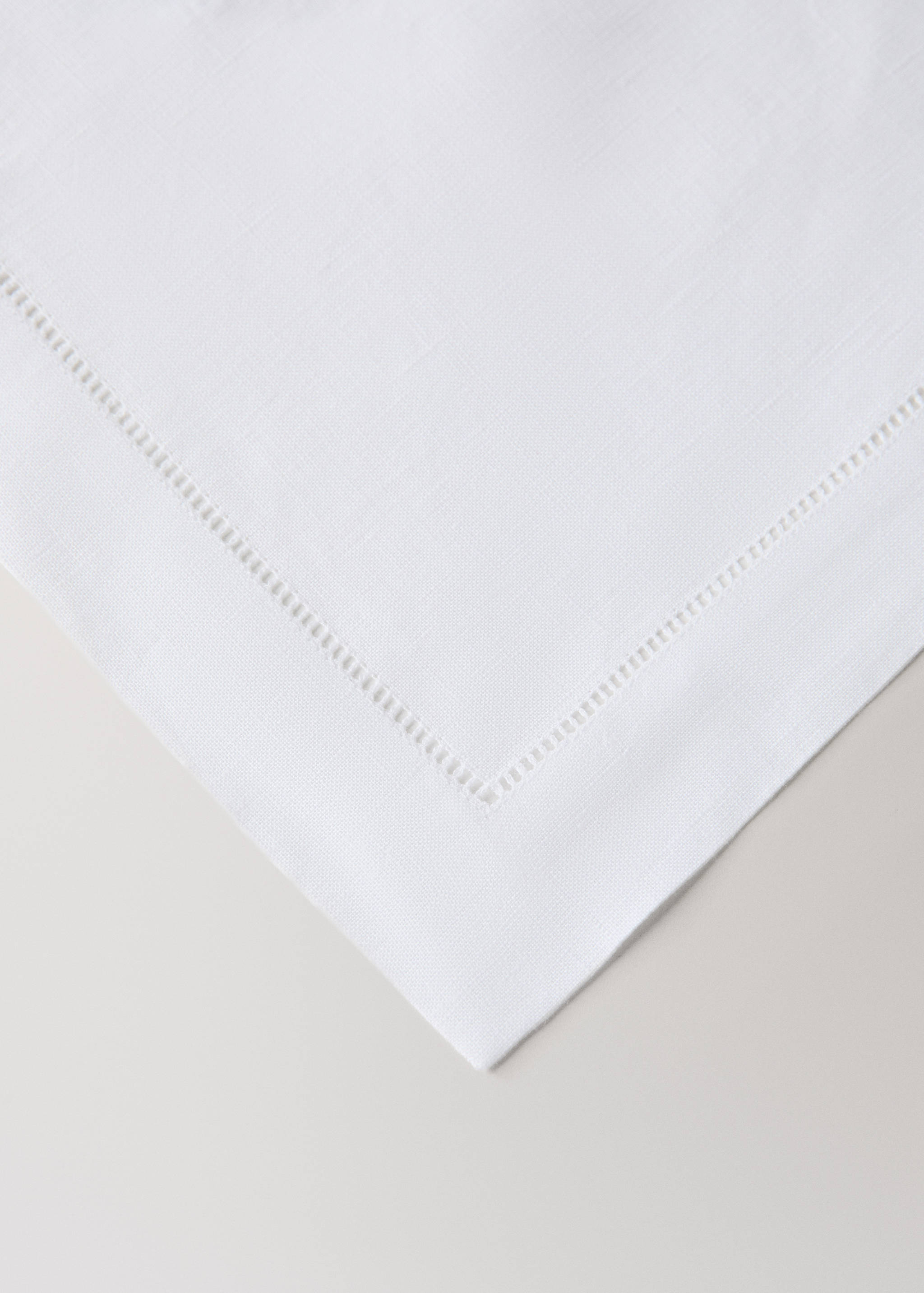 White placemat with a hemstitched border detail.