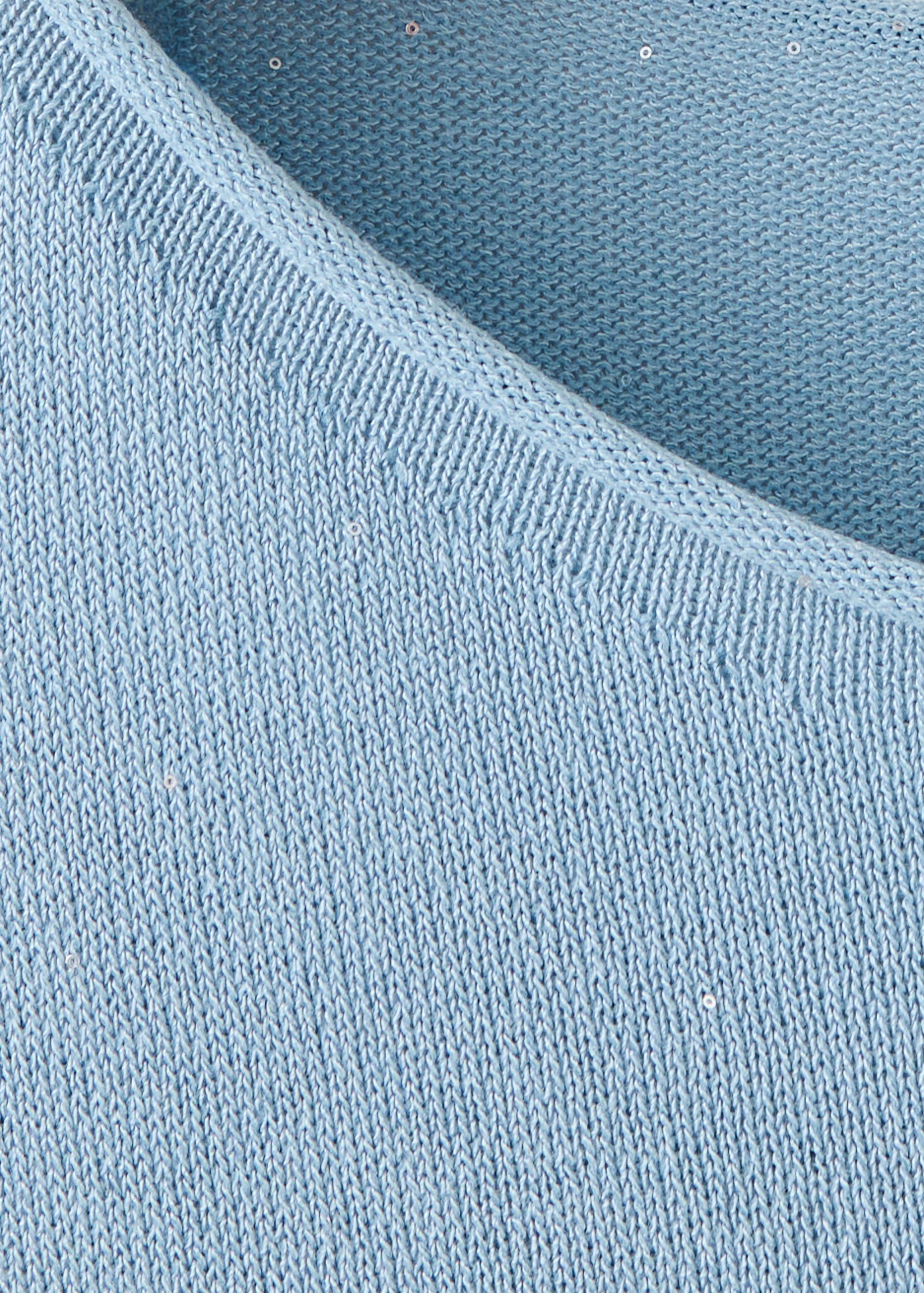 Close-up of a light blue knit sweater with subtle sequins.
