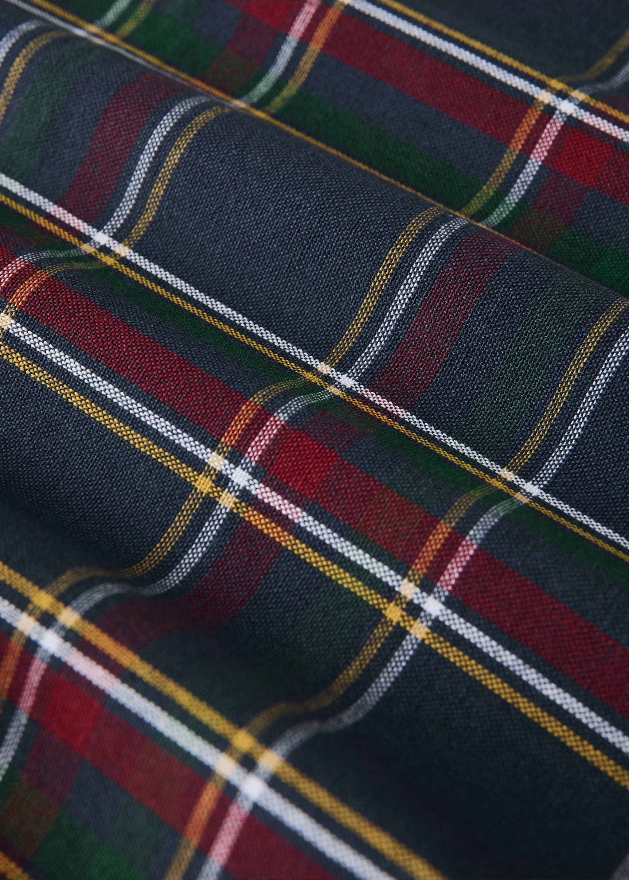 Close-up of a dark grey tablecloth with a red, green, and yellow tartan check pattern., Blue. Ref: 37026737-00.