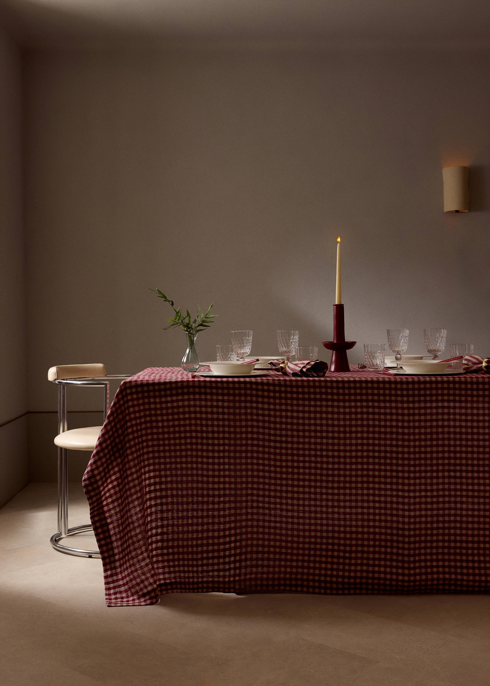Red and white checkered tablecloth on a set dining table.