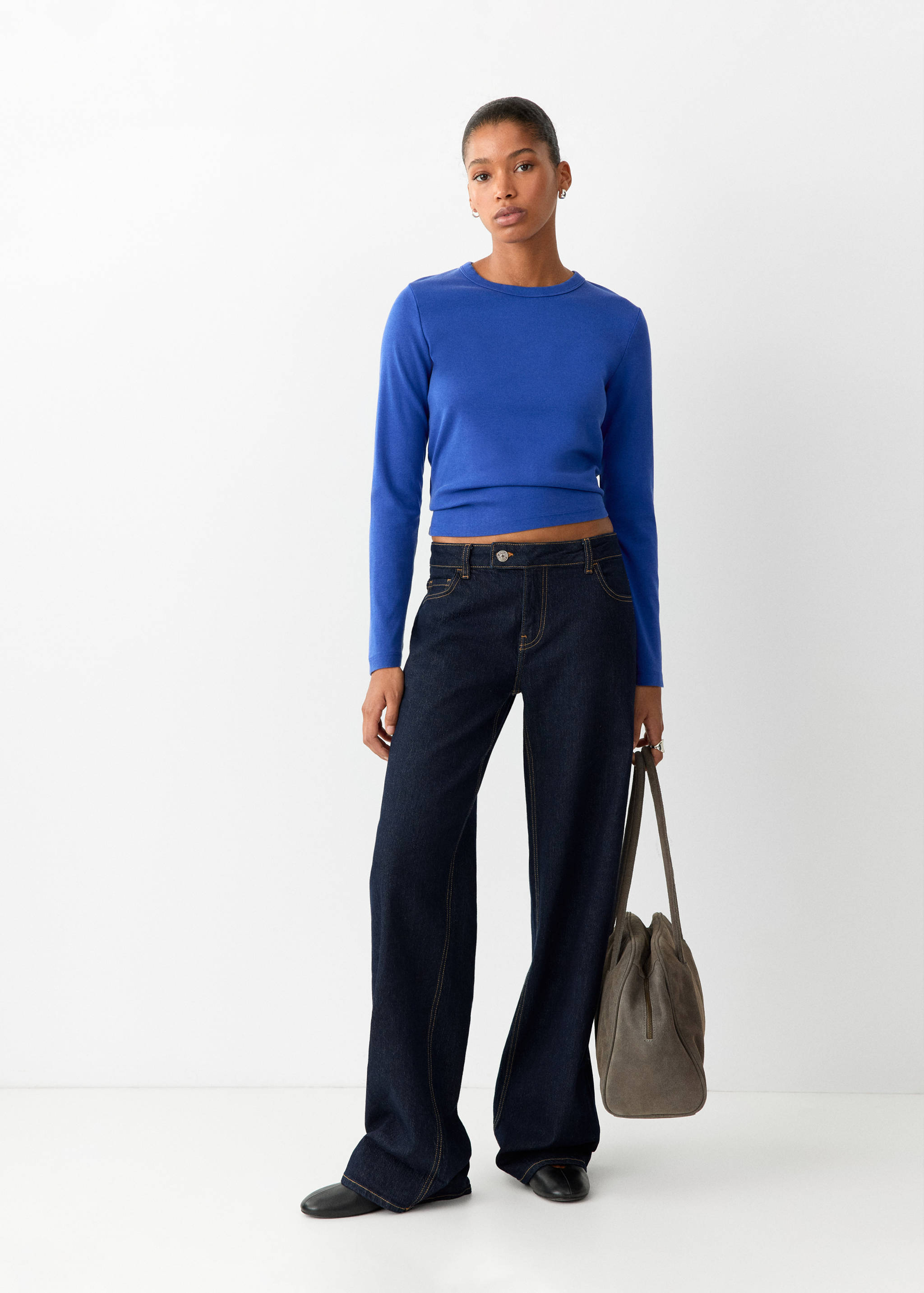 Royal blue long-sleeved t-shirt worn with dark blue wide-leg jeans.