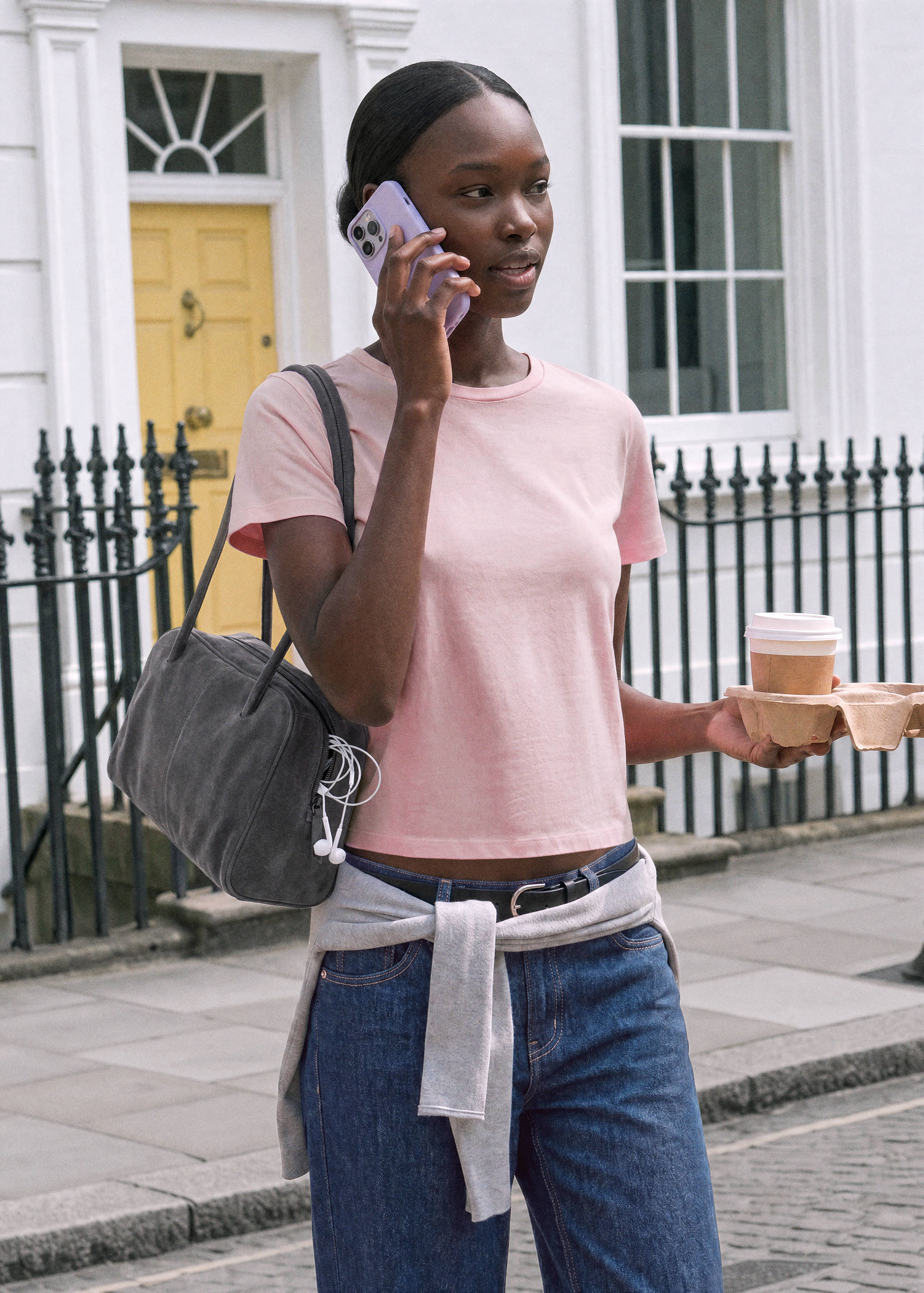 Pink short-sleeved t-shirt with a round neckline, worn outdoors.