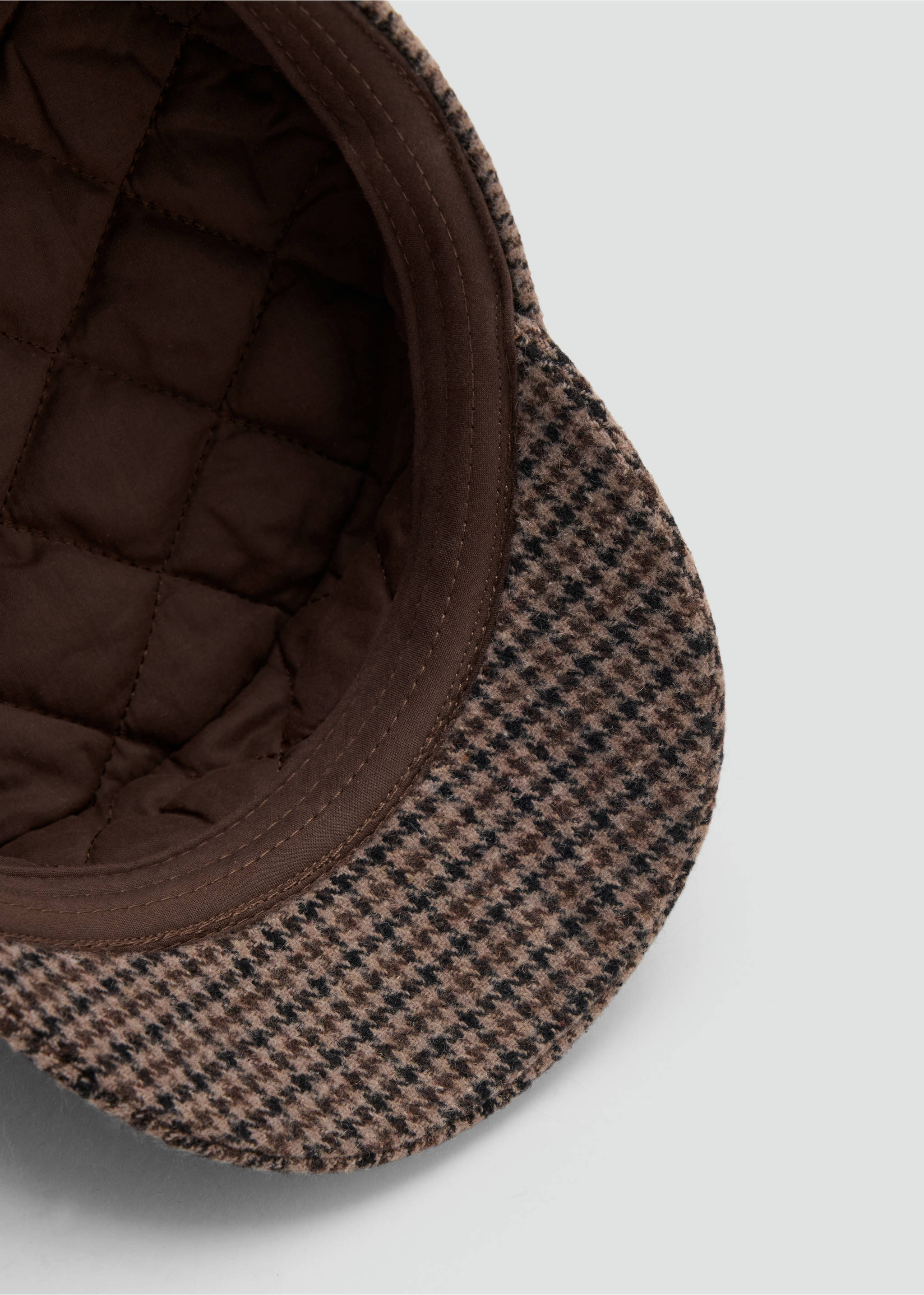 Close-up of a brown houndstooth cap with a quilted lining., Chocolate. Ref: 37027120-00.