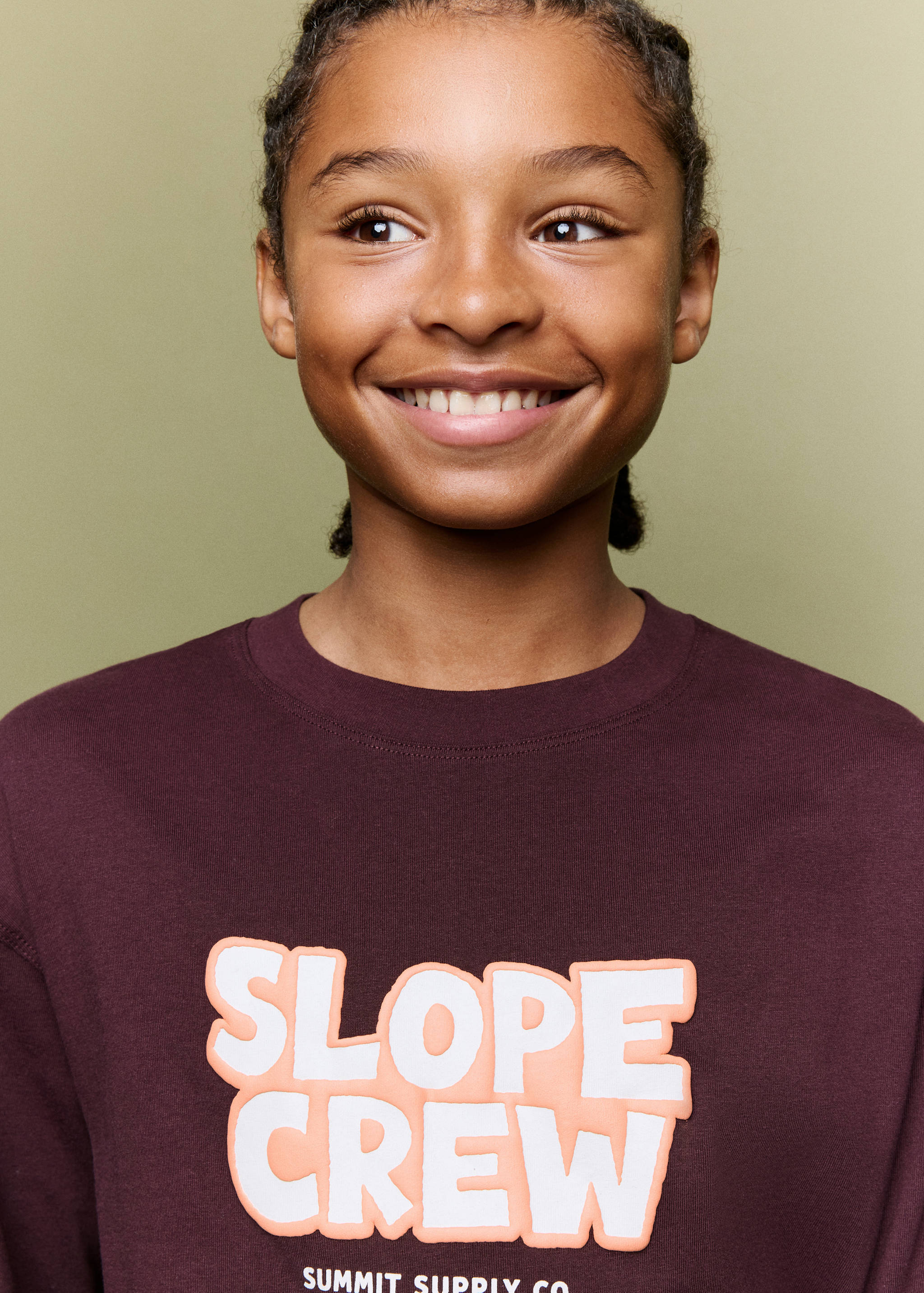 Burgundy t-shirt with raised white and peach 'SLOPE CREW' text, shown in a face detail view.