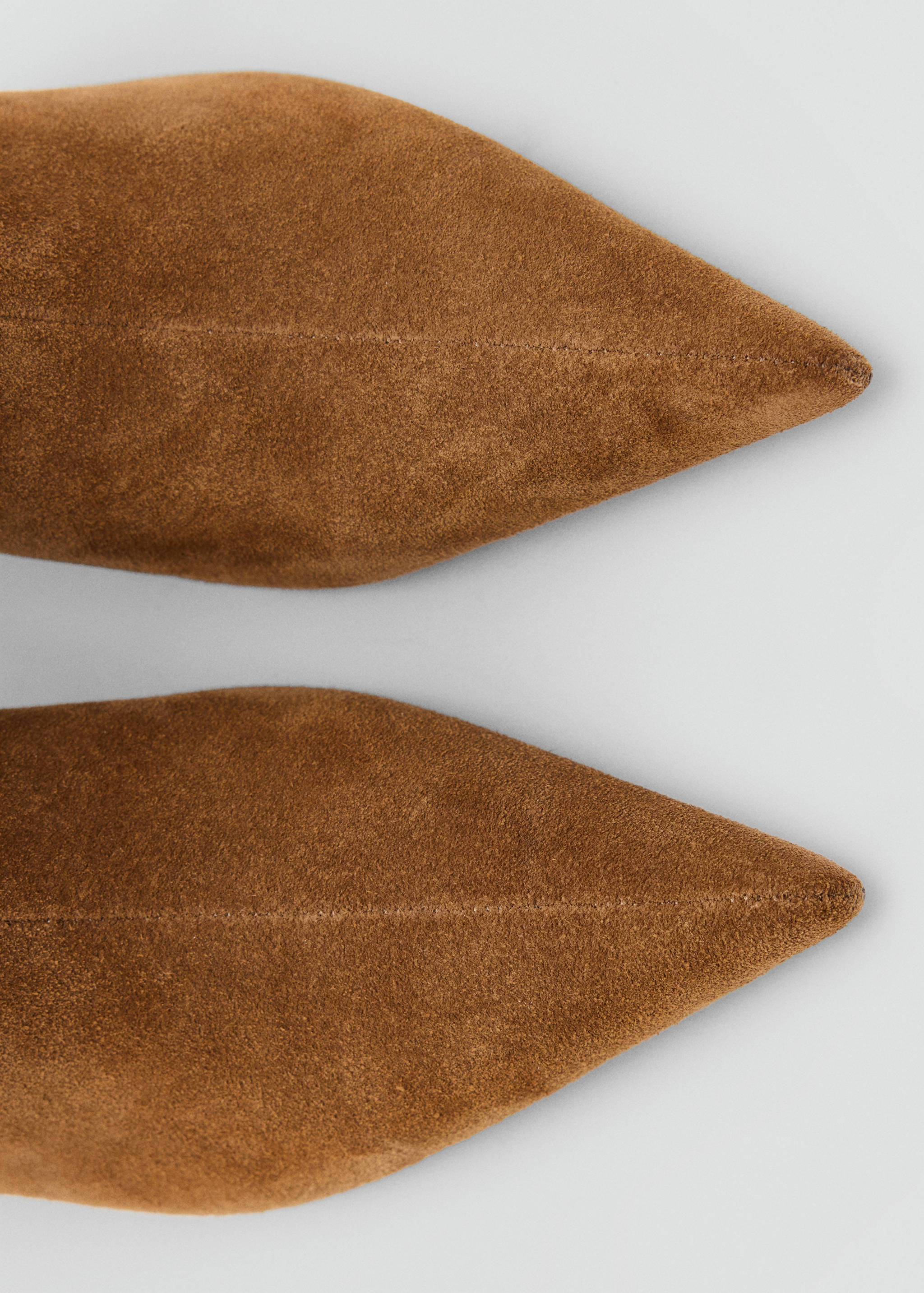 Close-up of brown suede ankle boots with pointed toes.