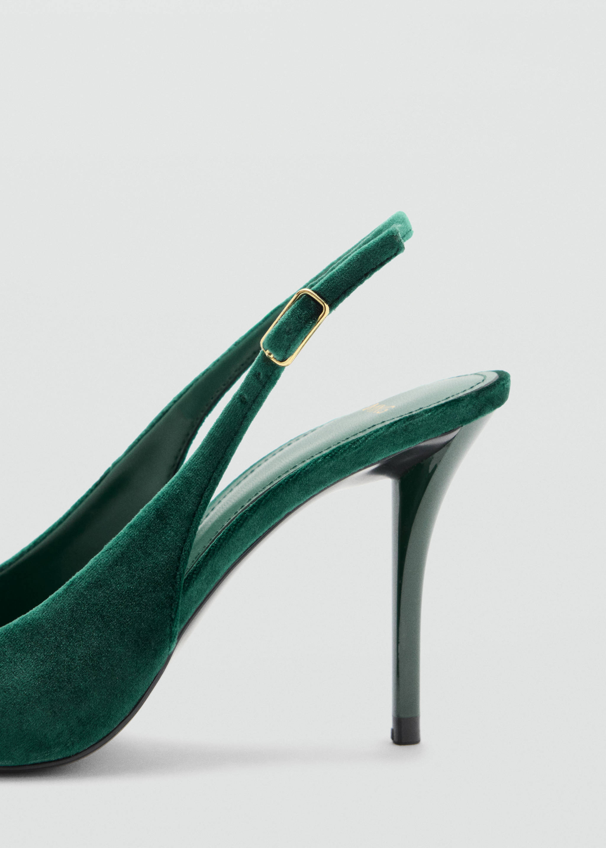 Dark green velvet slingback shoe detail with a thin adjustable heel strap.