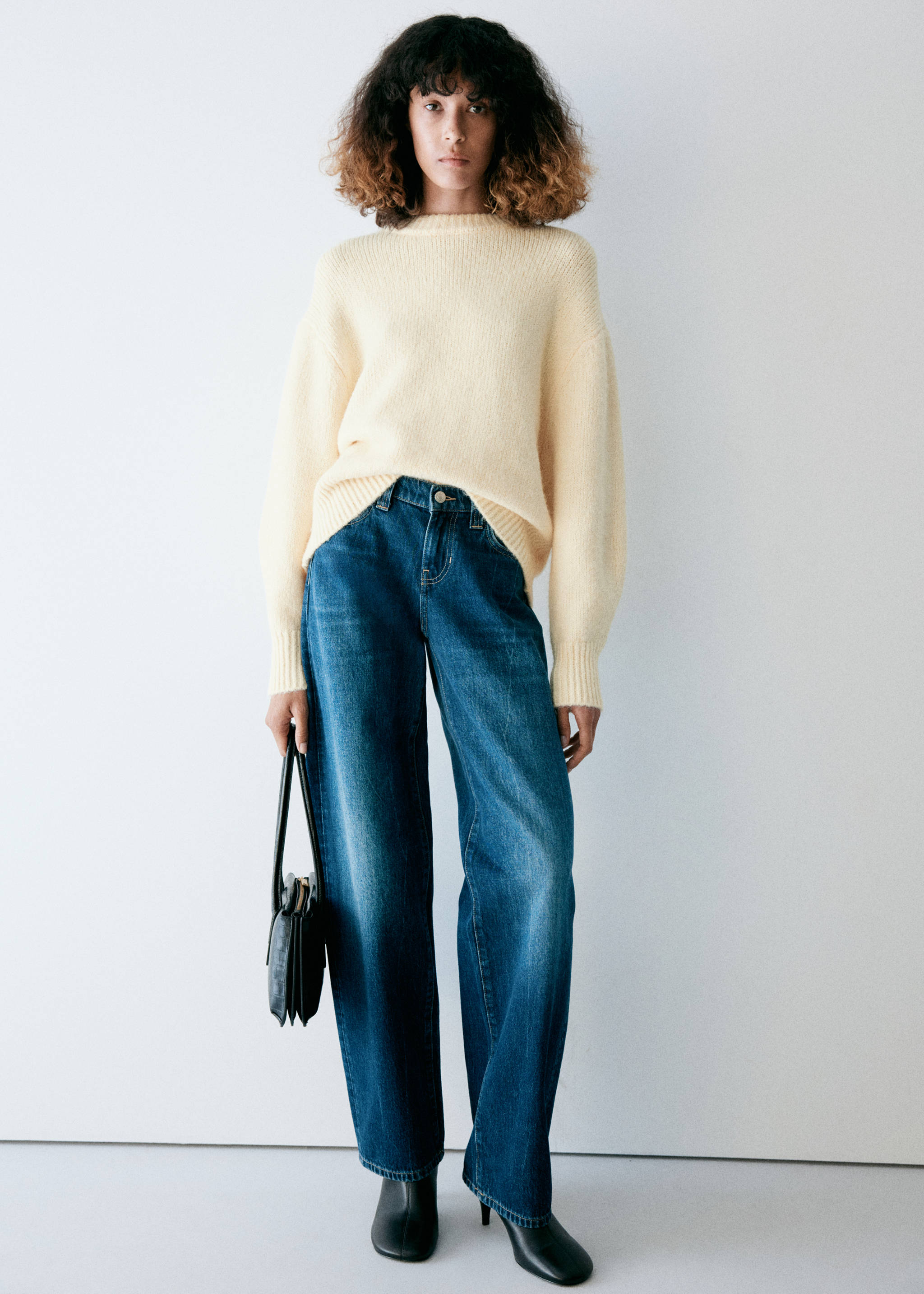 Pale yellow knitted jersey with a rounded neckline and long sleeves.
