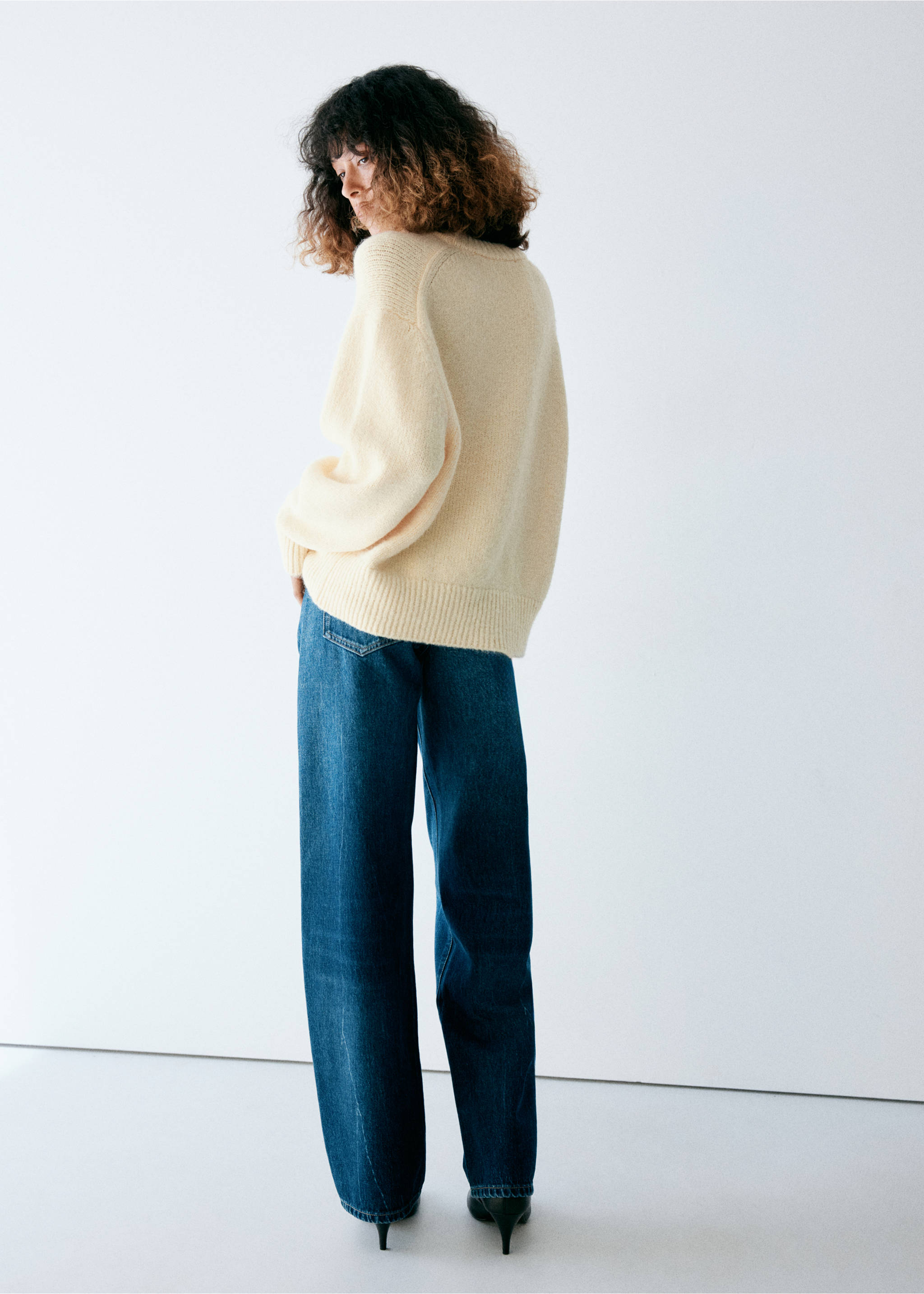 Pale yellow knit jersey sweater, back view, paired with blue trousers., Pastel Yellow. Ref: 37027788-00.