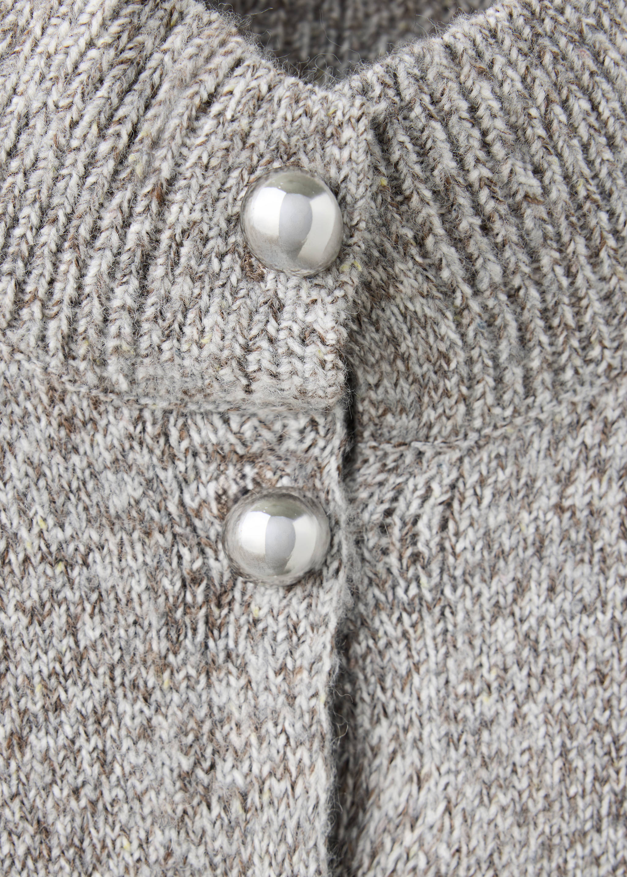 Close-up of a grey knit cardigan featuring a ribbed neckline and silver buttons.