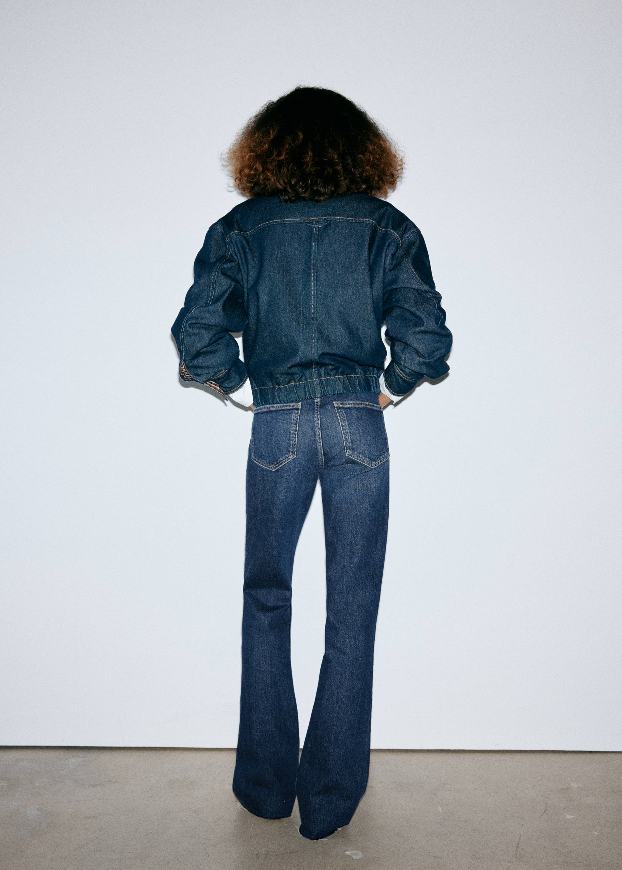 Dark blue denim jacket and flare trousers, back view