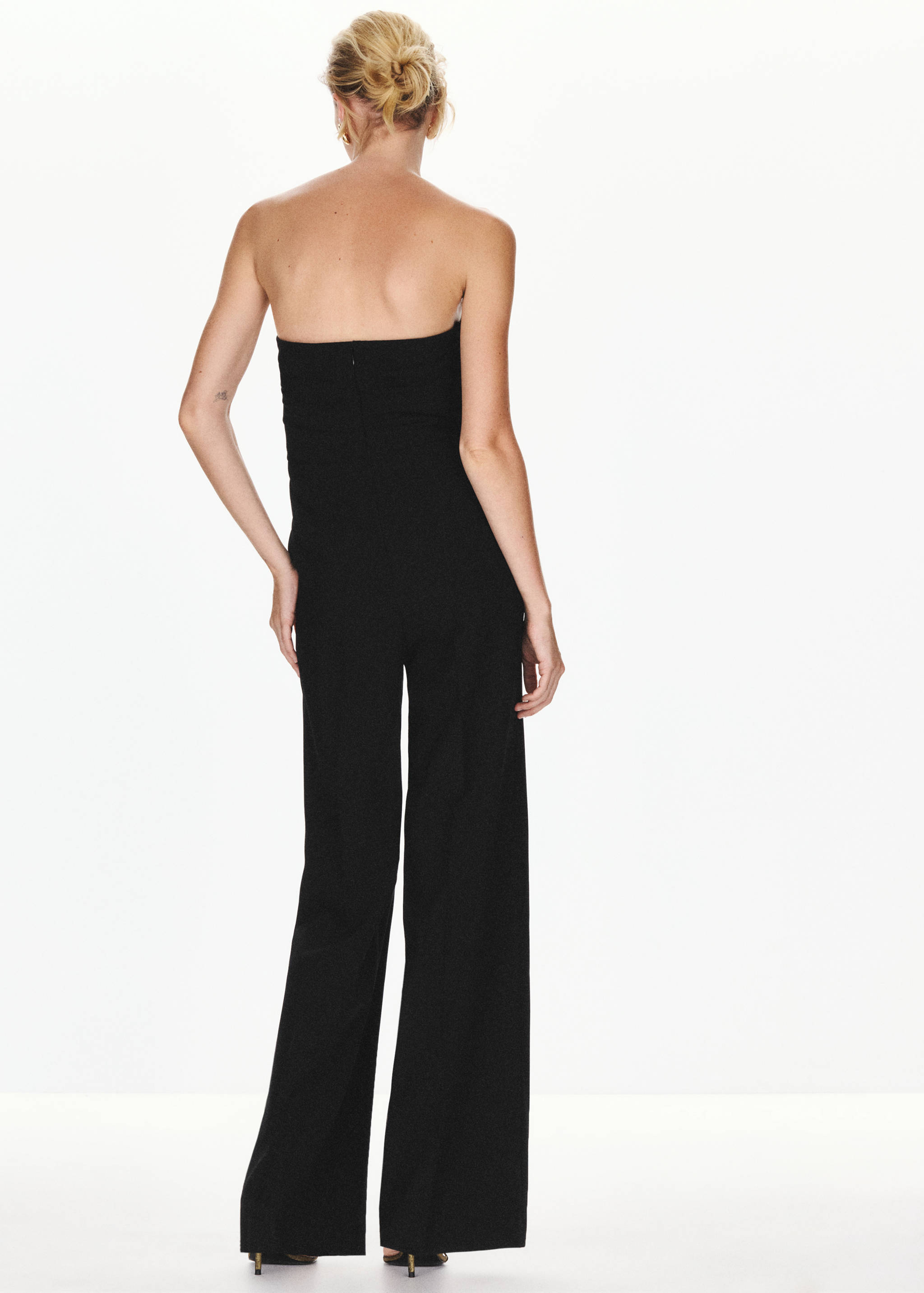 Black strapless jumpsuit seen from the back.