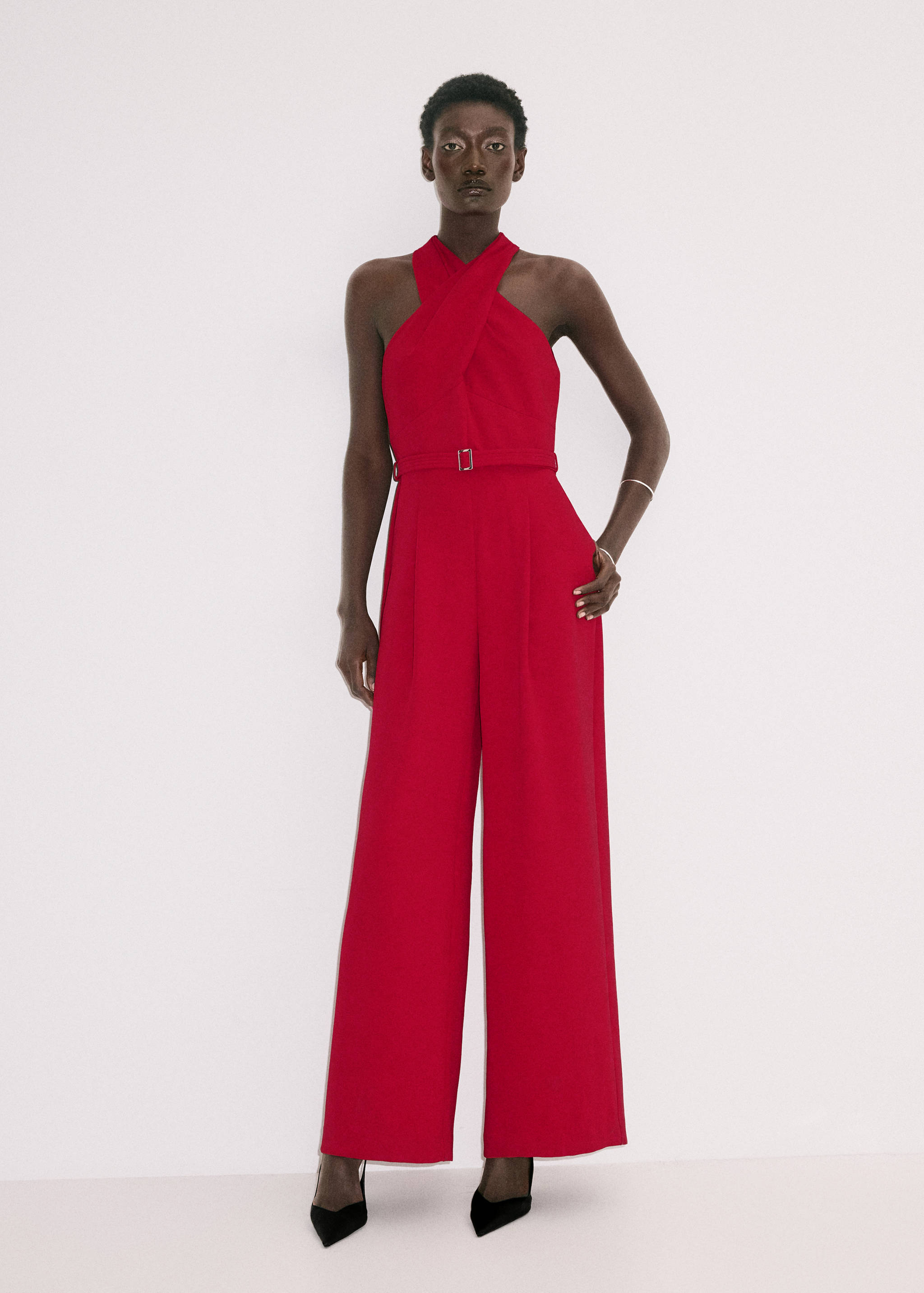 Red halter-neck wide-leg jumpsuit with a buckled belt.
