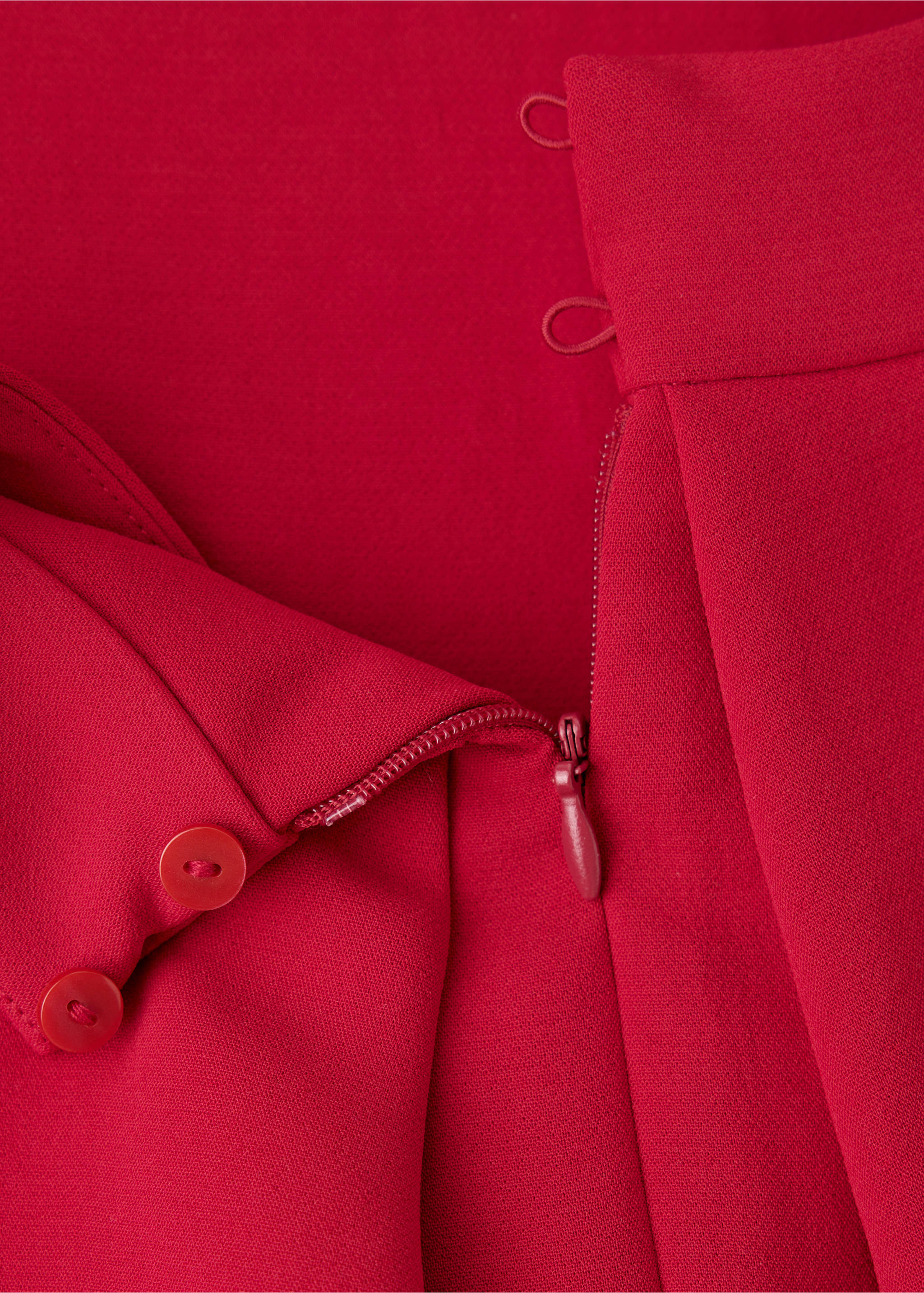 Red jumpsuit fabric detail showing zip and button closure., Red. Ref: 37027808-00.