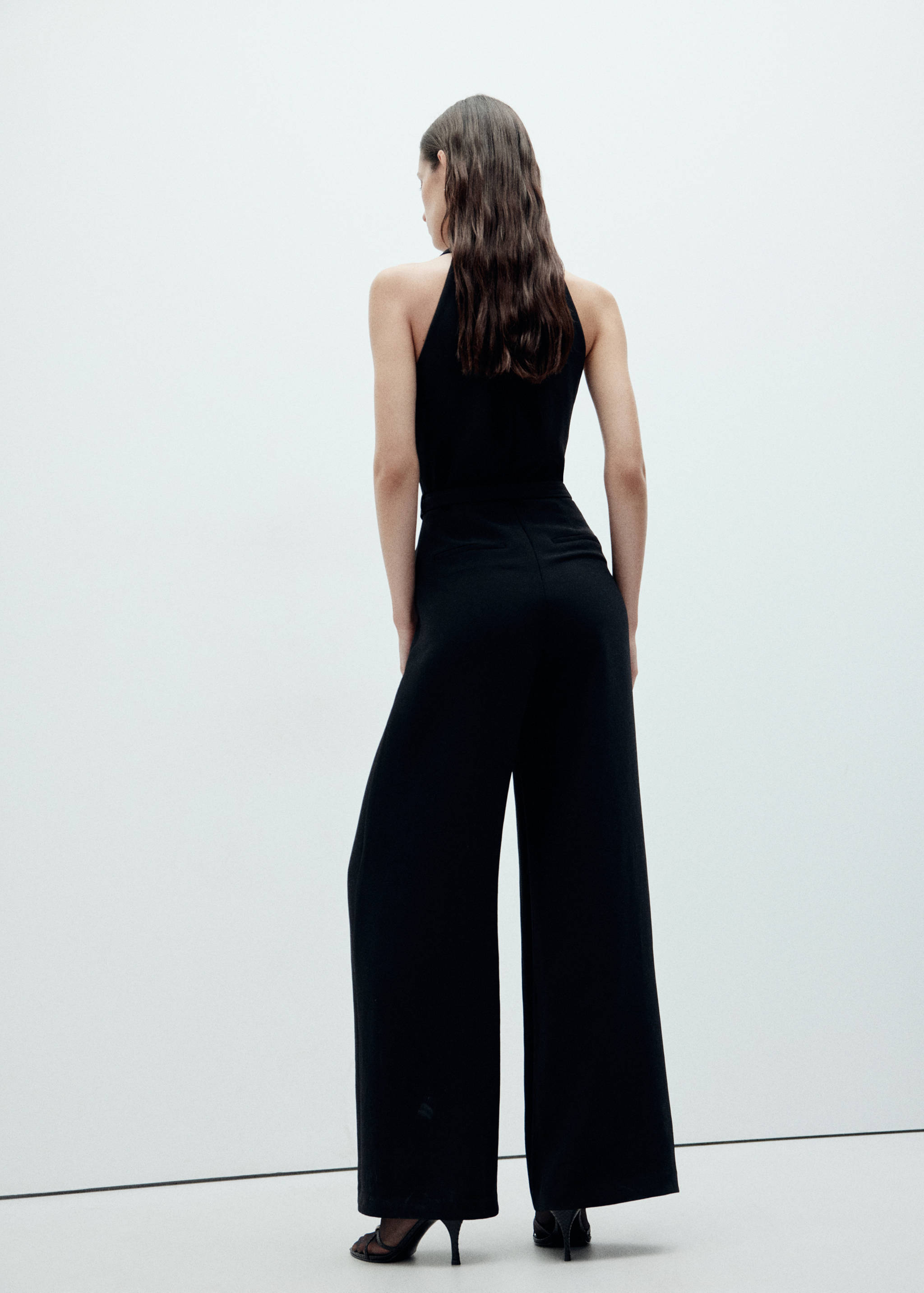 Back view of a black halter jumpsuit with wide-leg trousers