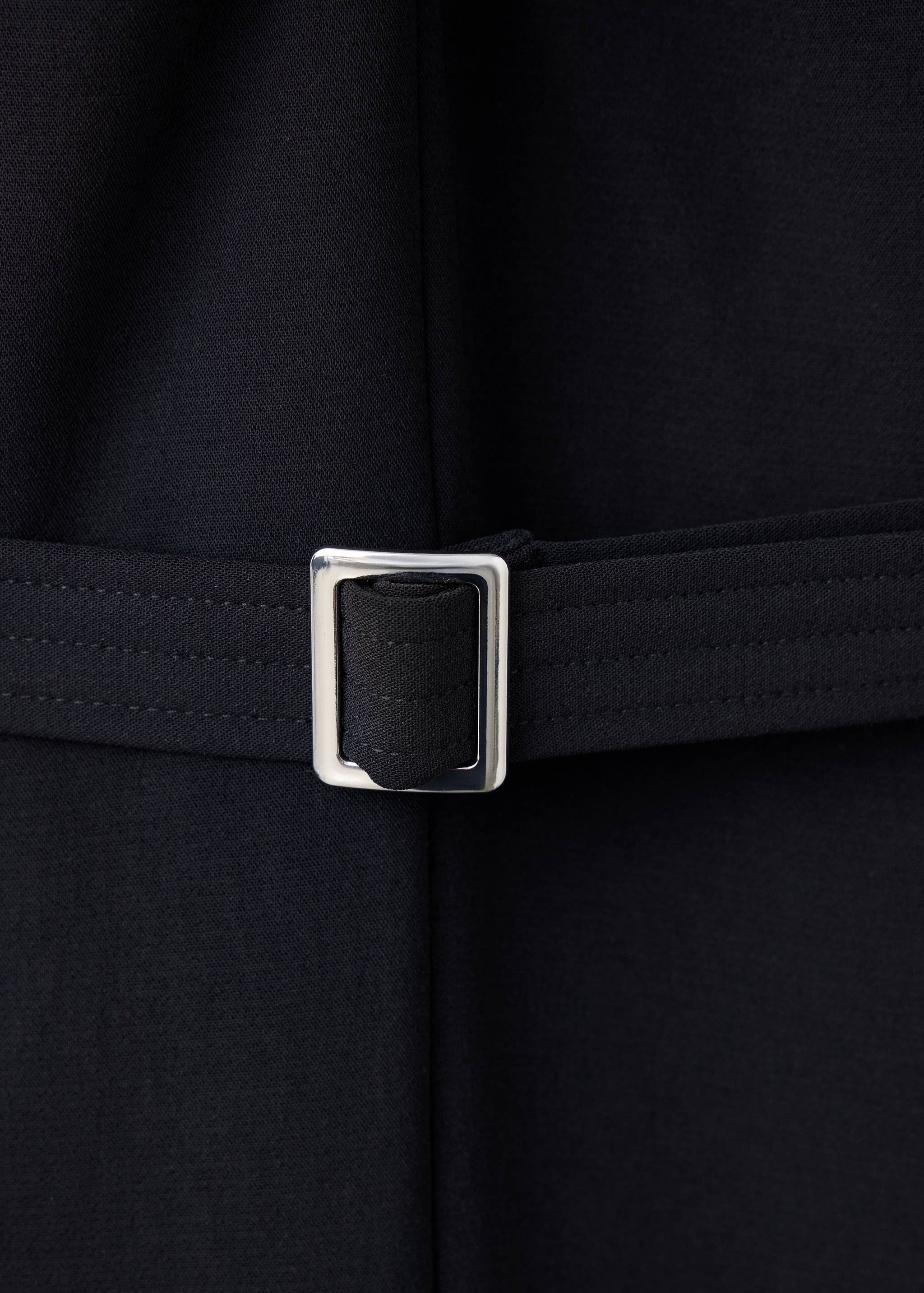 Black jumpsuit belt detail with a silver-toned metal buckle.