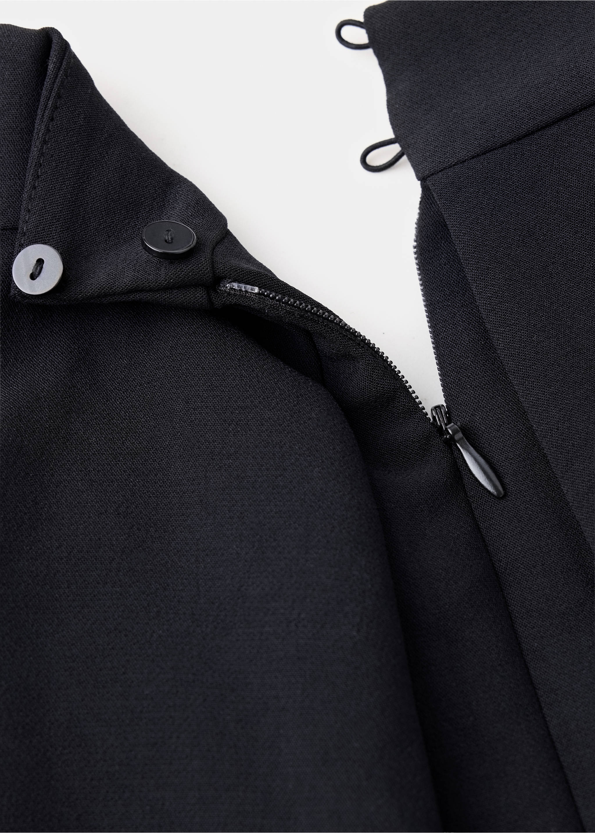 Black jumpsuit fabric detail showing the zip and button closure., Black. Ref: 37027808-00.