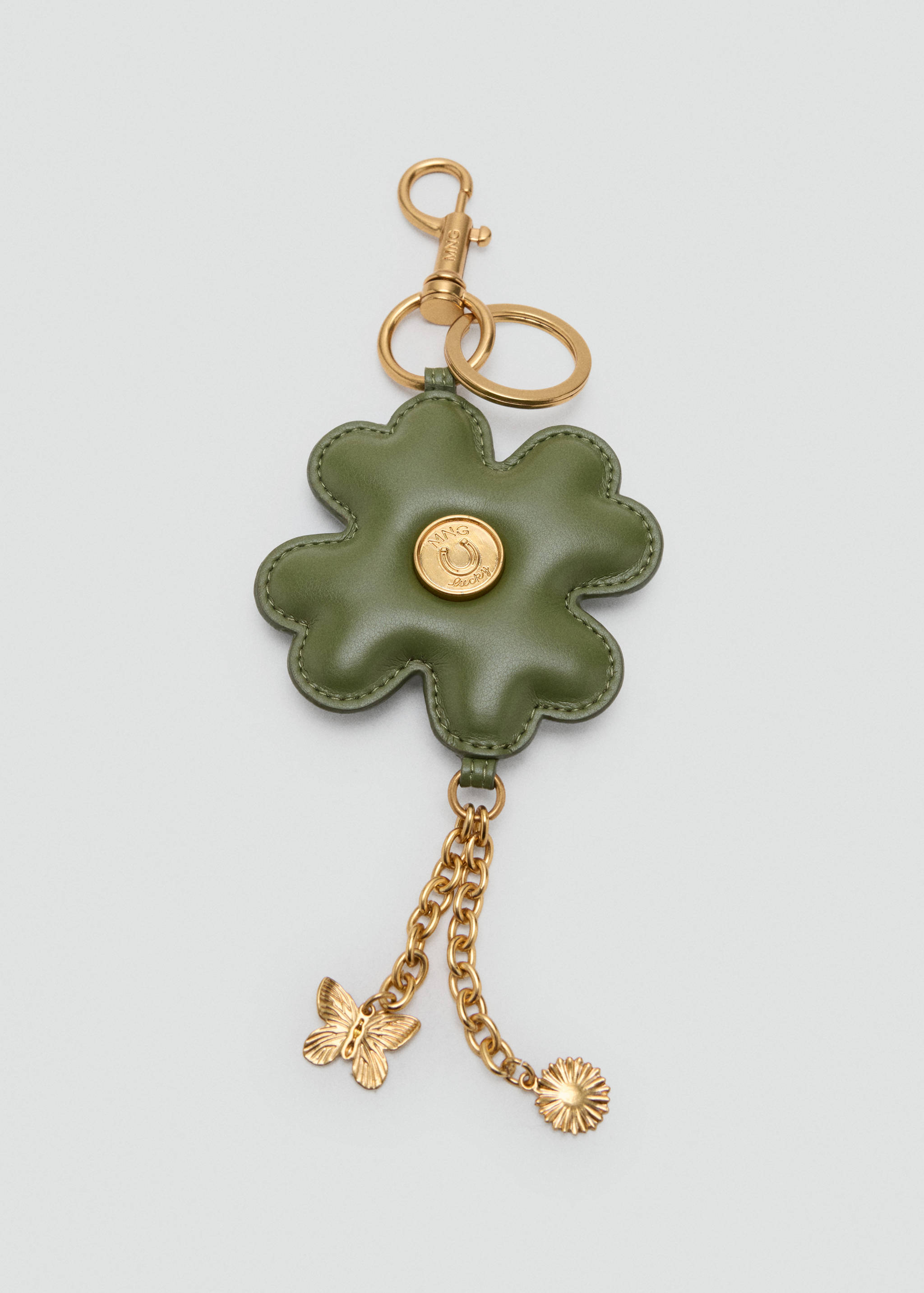 Green clover keychain with gold-tone hardware, butterfly charm, and chain details.