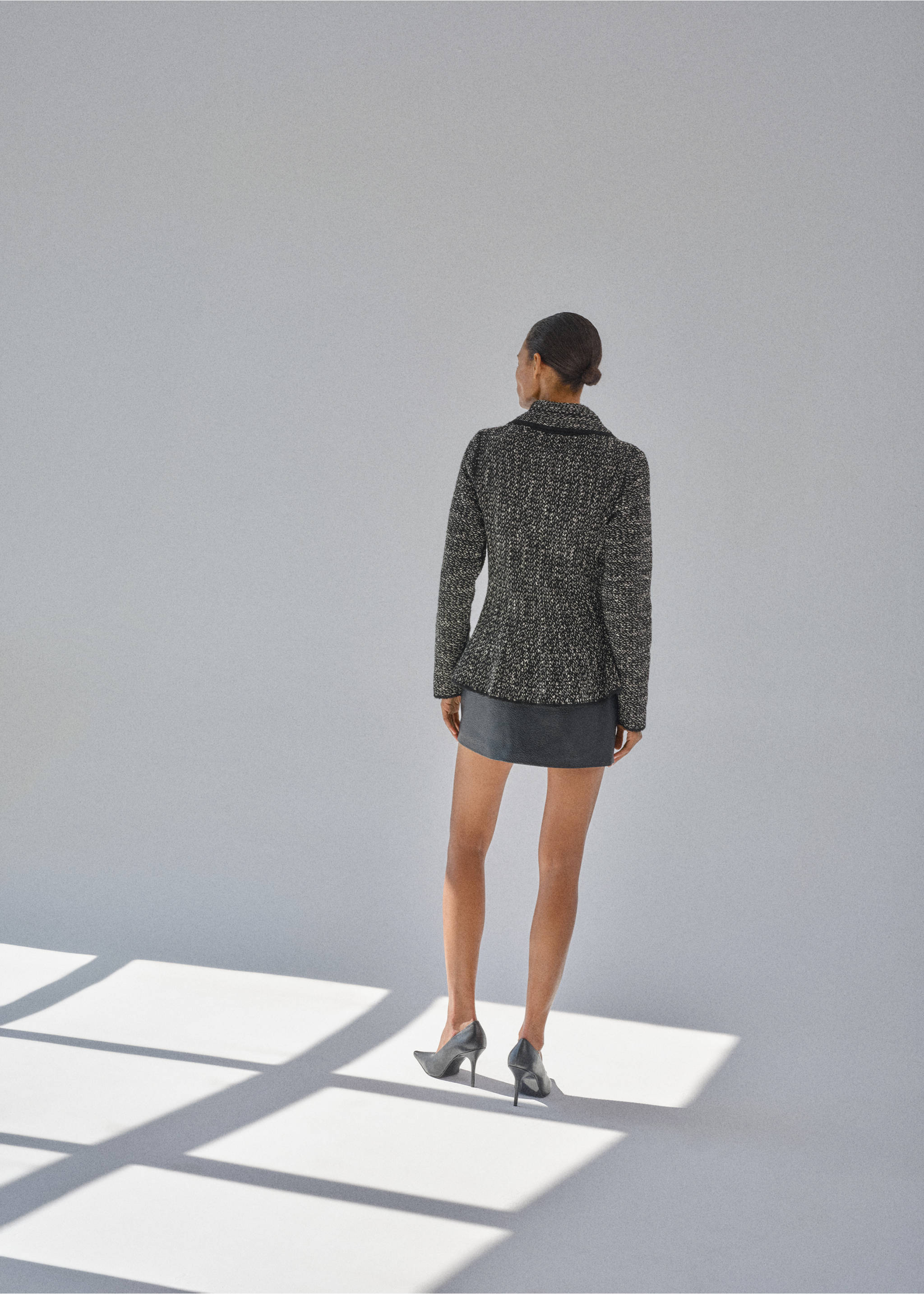Black and white tweed jacket with a peplum waist, shown from the back., Black. Ref: 37027811-00.