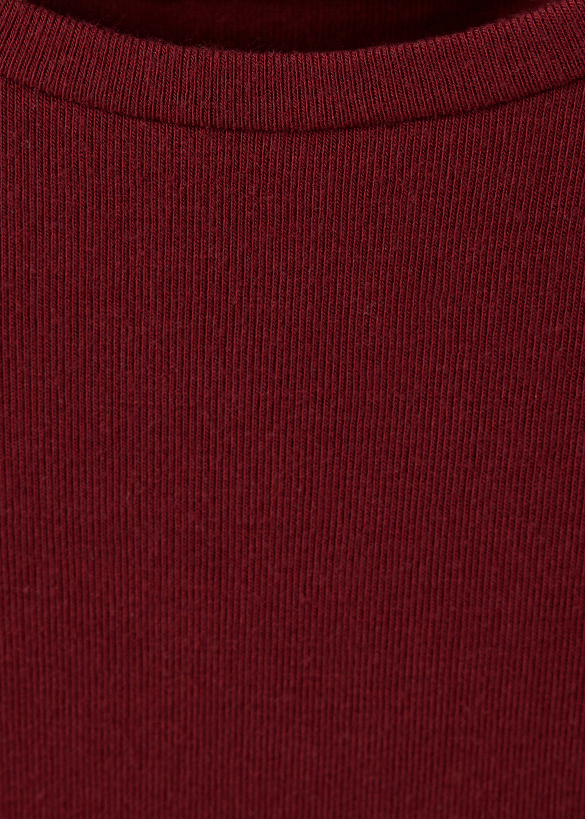 Close-up of the fine ribbed fabric and neckline of a dark red t-shirt.