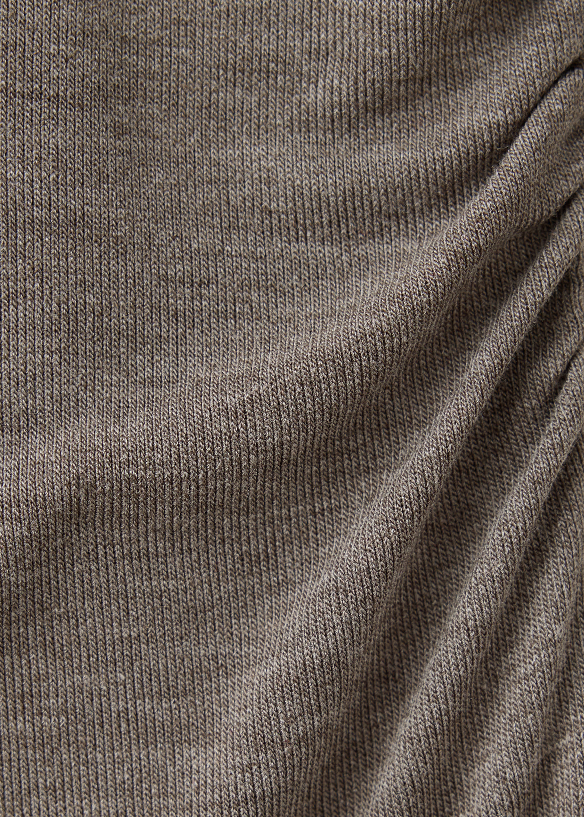 Close-up of brown ribbed knit fabric texture with side ruching.