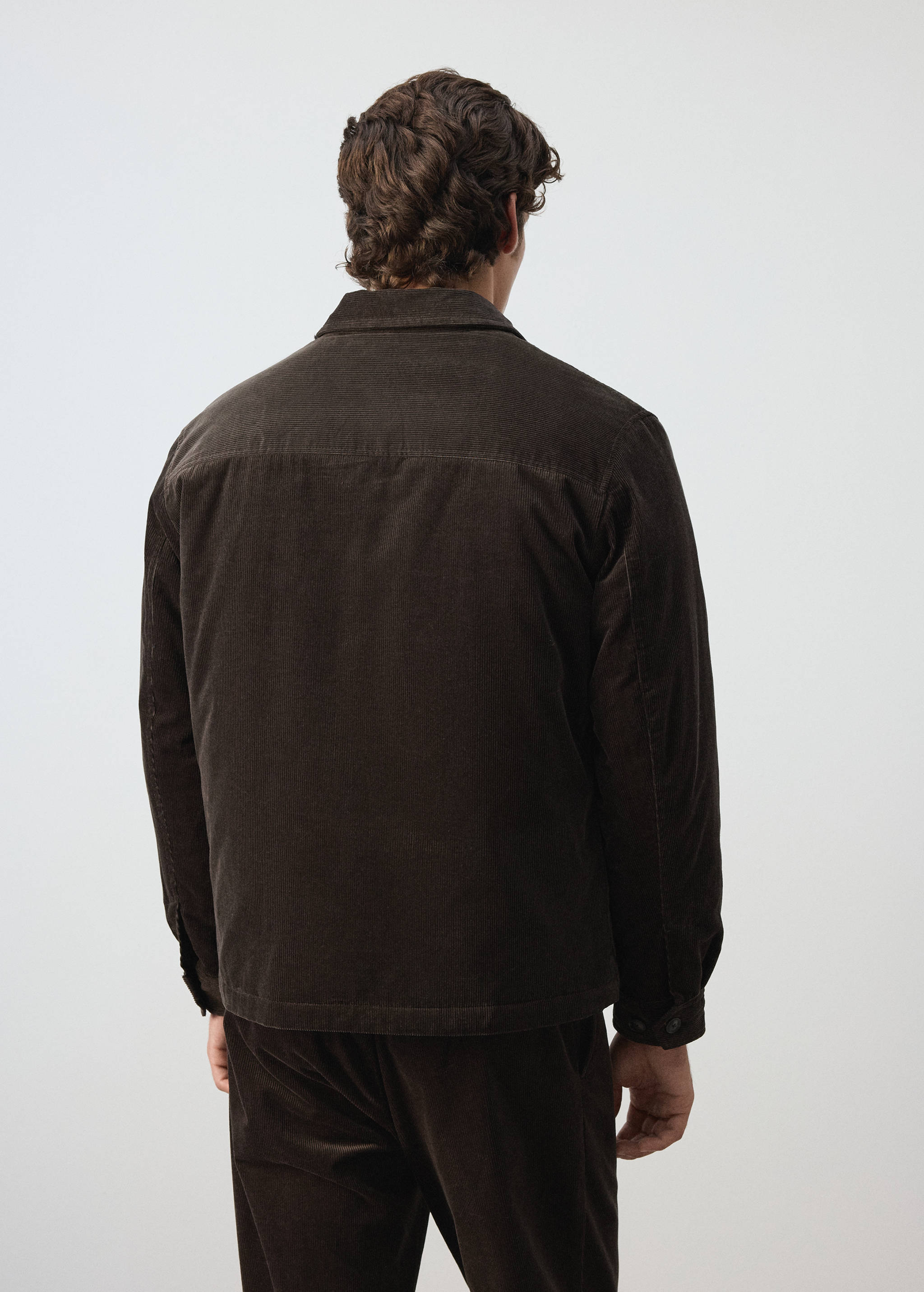 Dark brown corduroy jacket seen from the back, featuring a classic collar.
