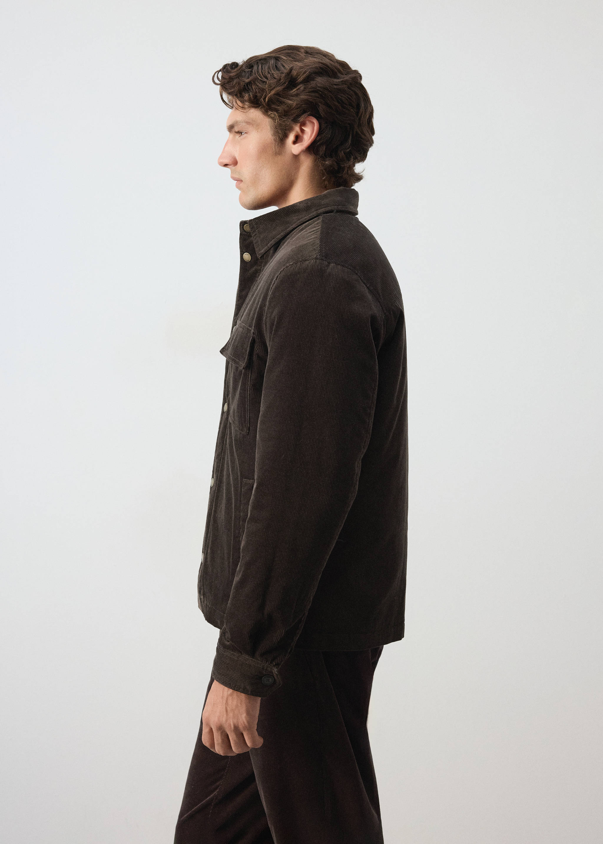 Dark brown corduroy jacket with a classic collar and chest pocket, shown in profile.