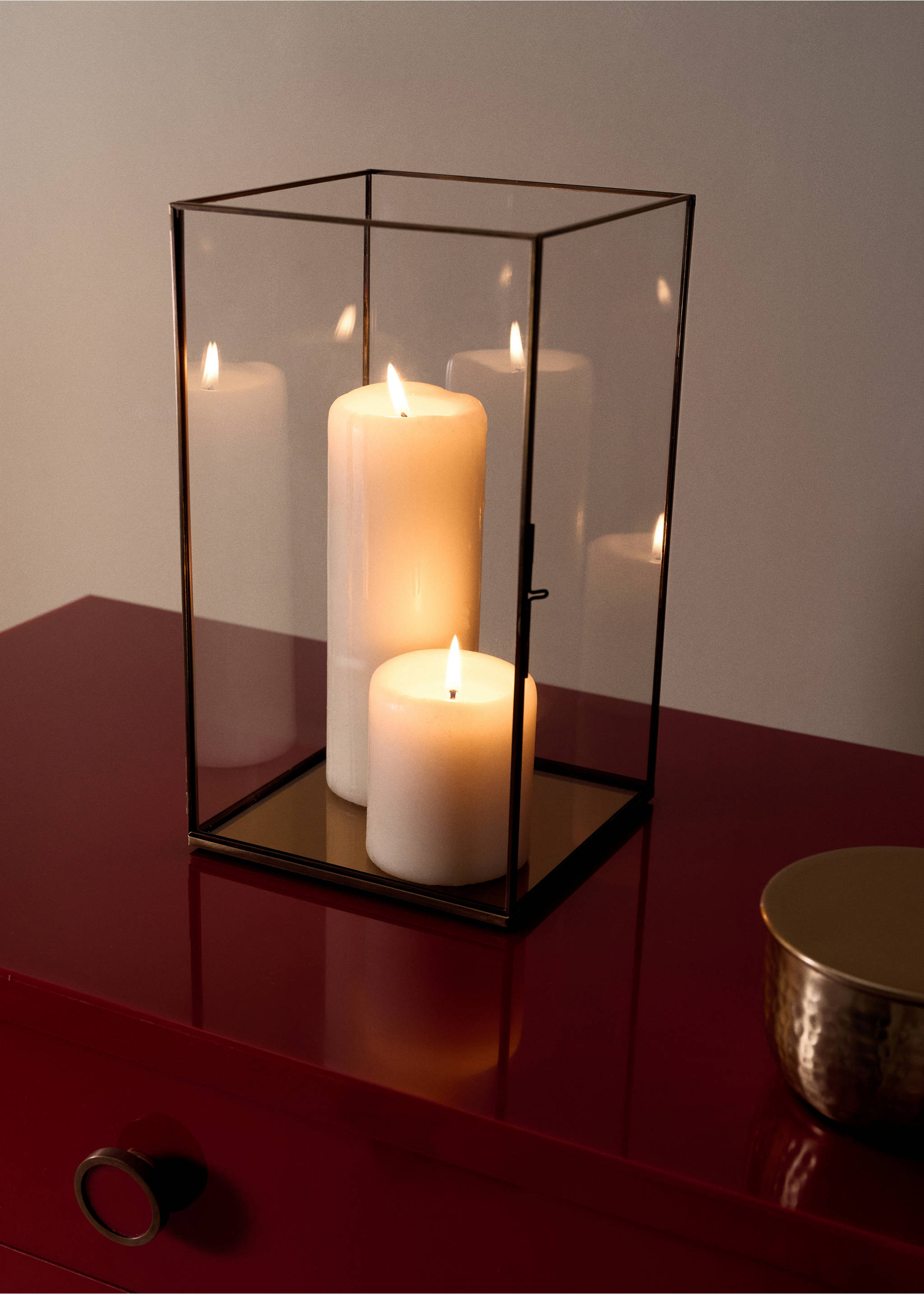 Rectangular glass candle holder with dark metal framing and two lit white pillar candles inside., Black. Ref: 37027893-00.