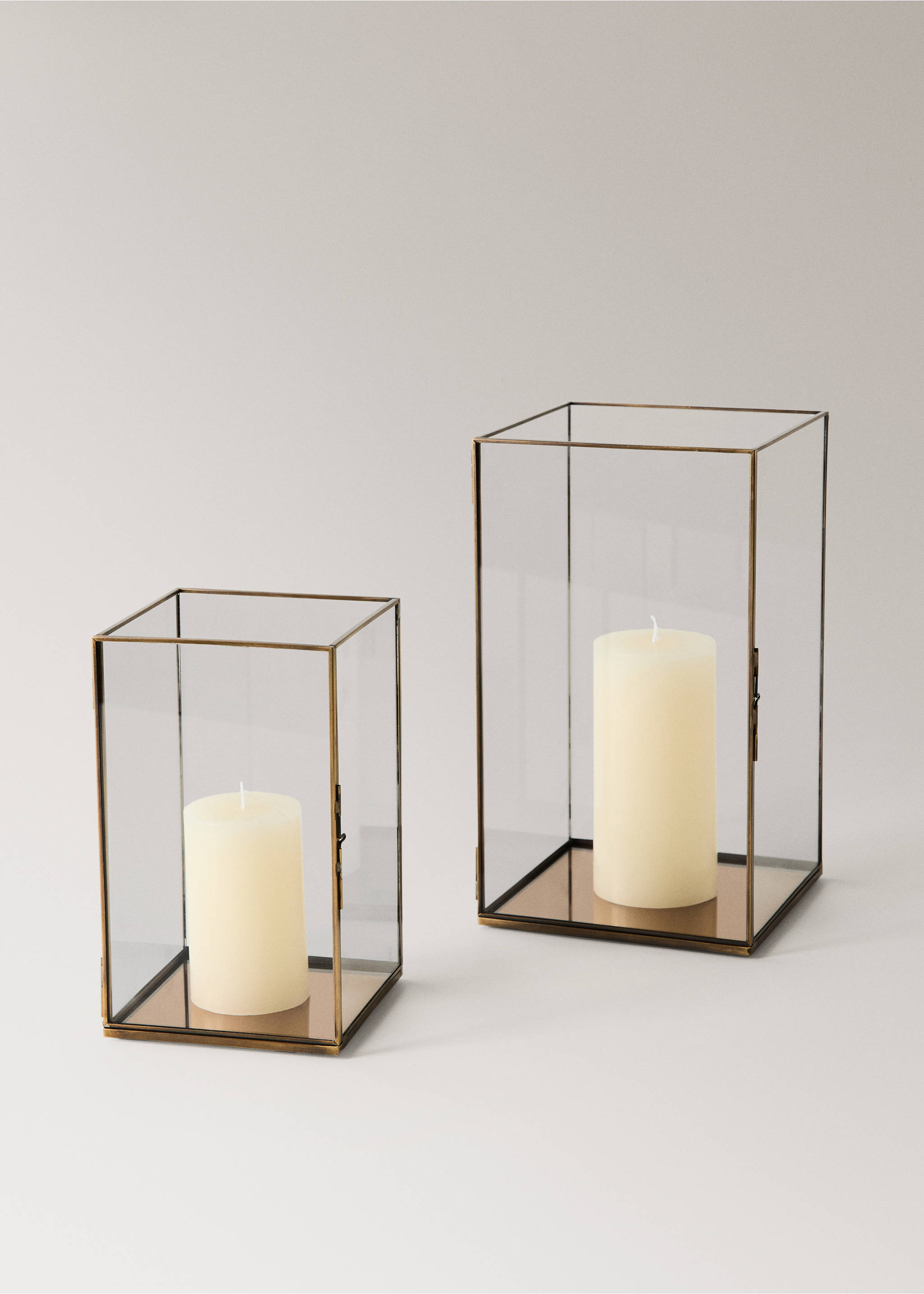 Two rectangular glass candle holders with brass frames and ivory pillar candles., Black. Ref: 37027893-00.